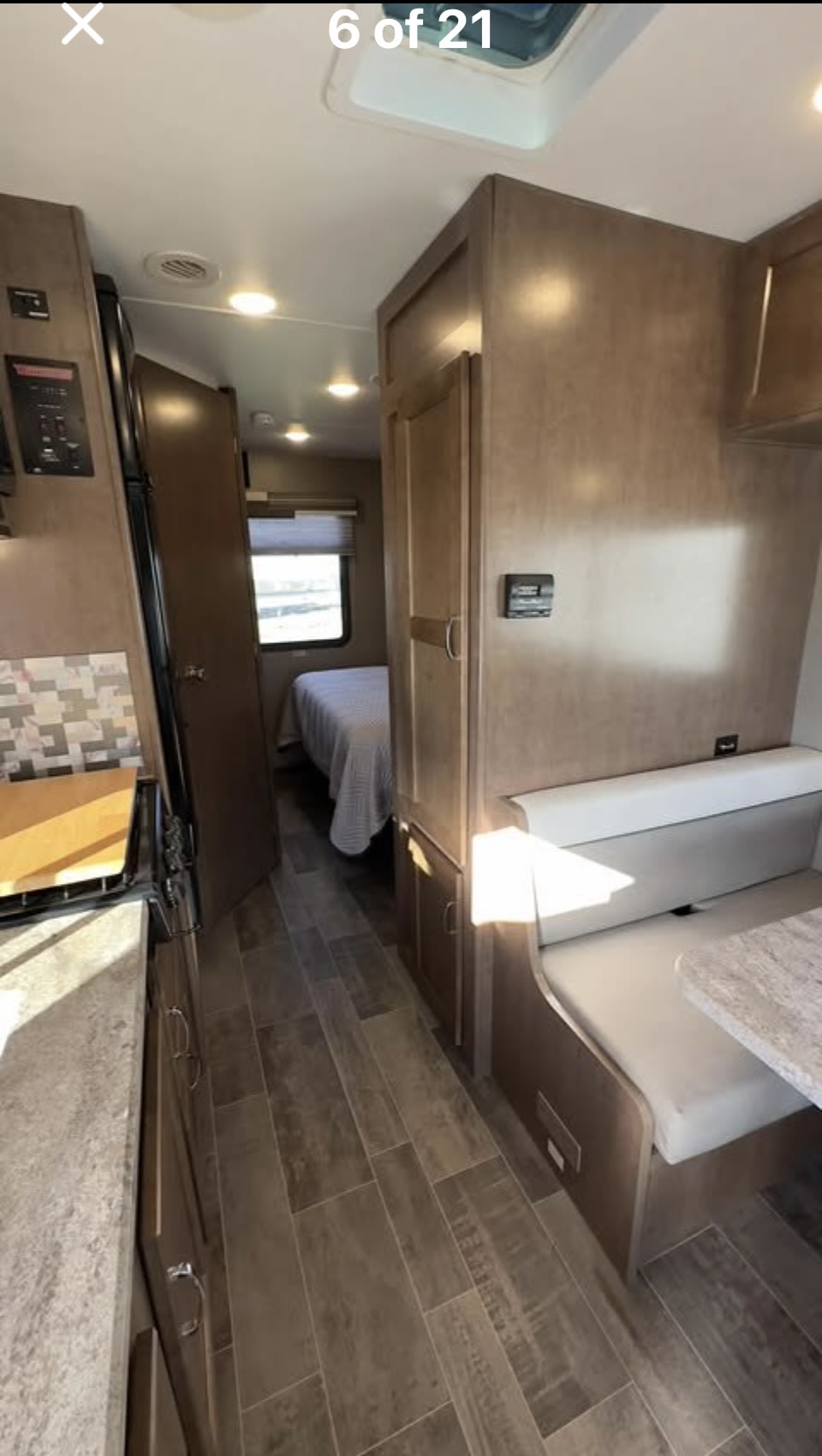 RV rental interior showing kitchen, hallway to bedroom, and dinette seating. Modern compact living space.. Winnebago Outlook 2019