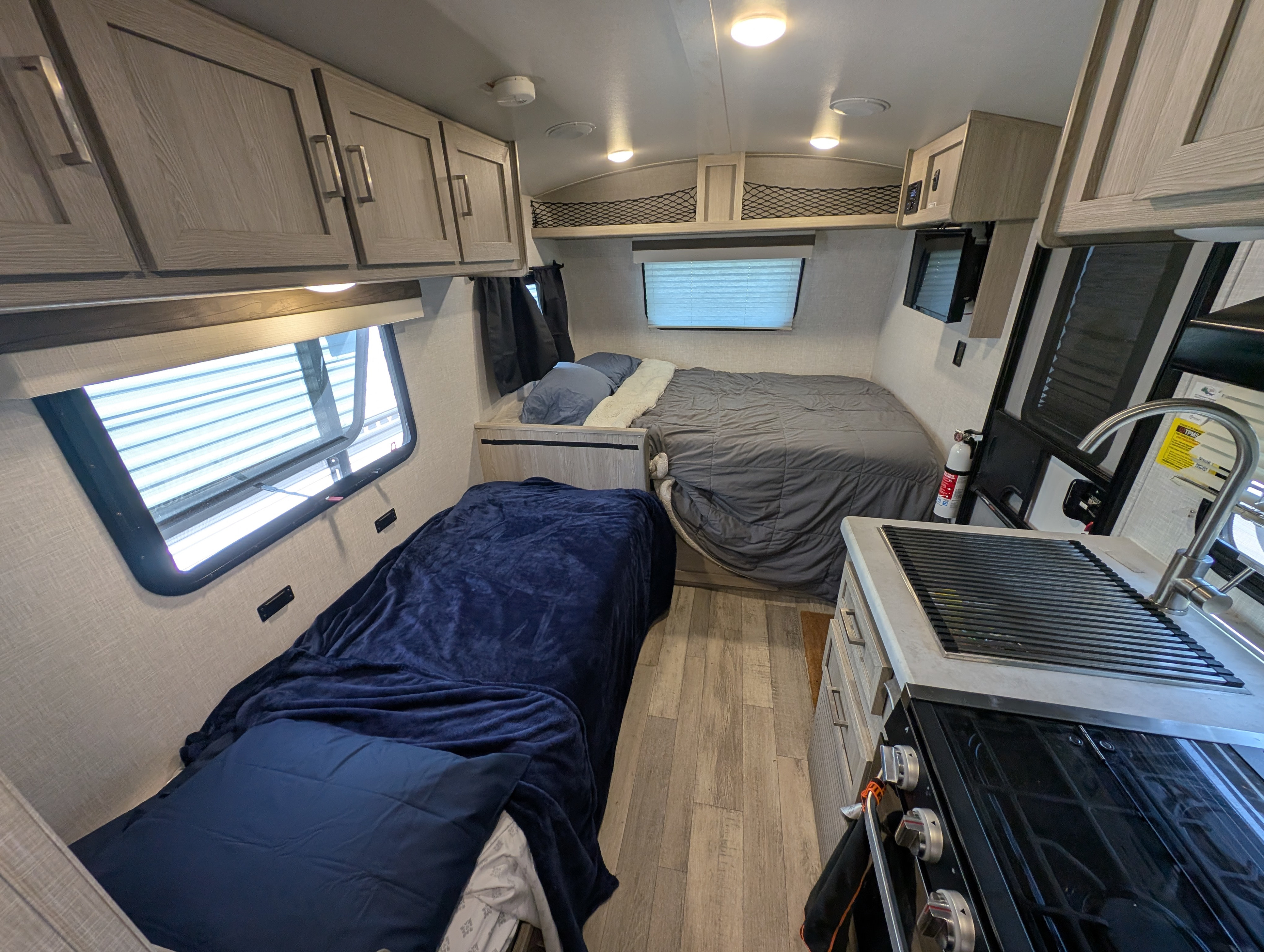 Cozy RV rental interior with two comfortable beds, a functional kitchenette, and ample storage for your journey.. Forest River Rockwood Geo Pro 2022