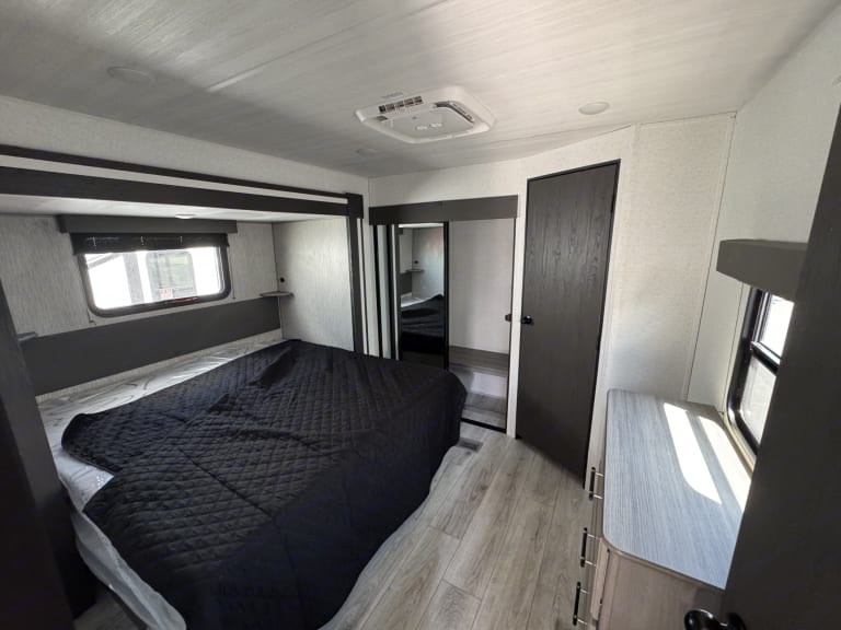 Step into this inviting RV rental bedroom with a comfy bed, window, mirrored closet, and dresser.. evergreen sun valley 2015