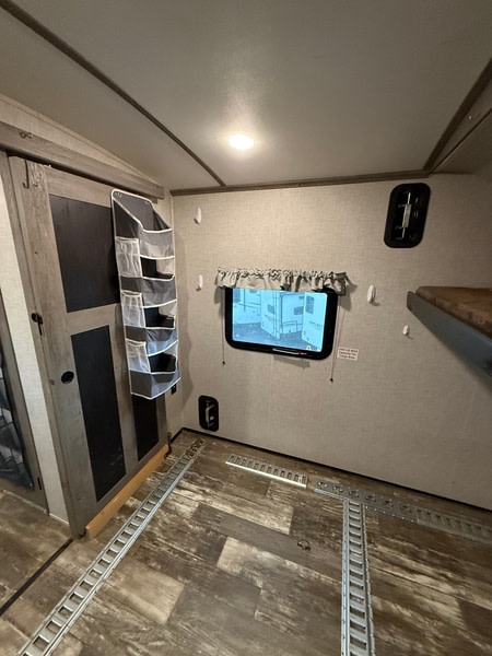 Inside an RV rental: This toy hauler features versatile floor tracks, a window, and bunk bed, perfect for gear.. Keystone Outback 2020