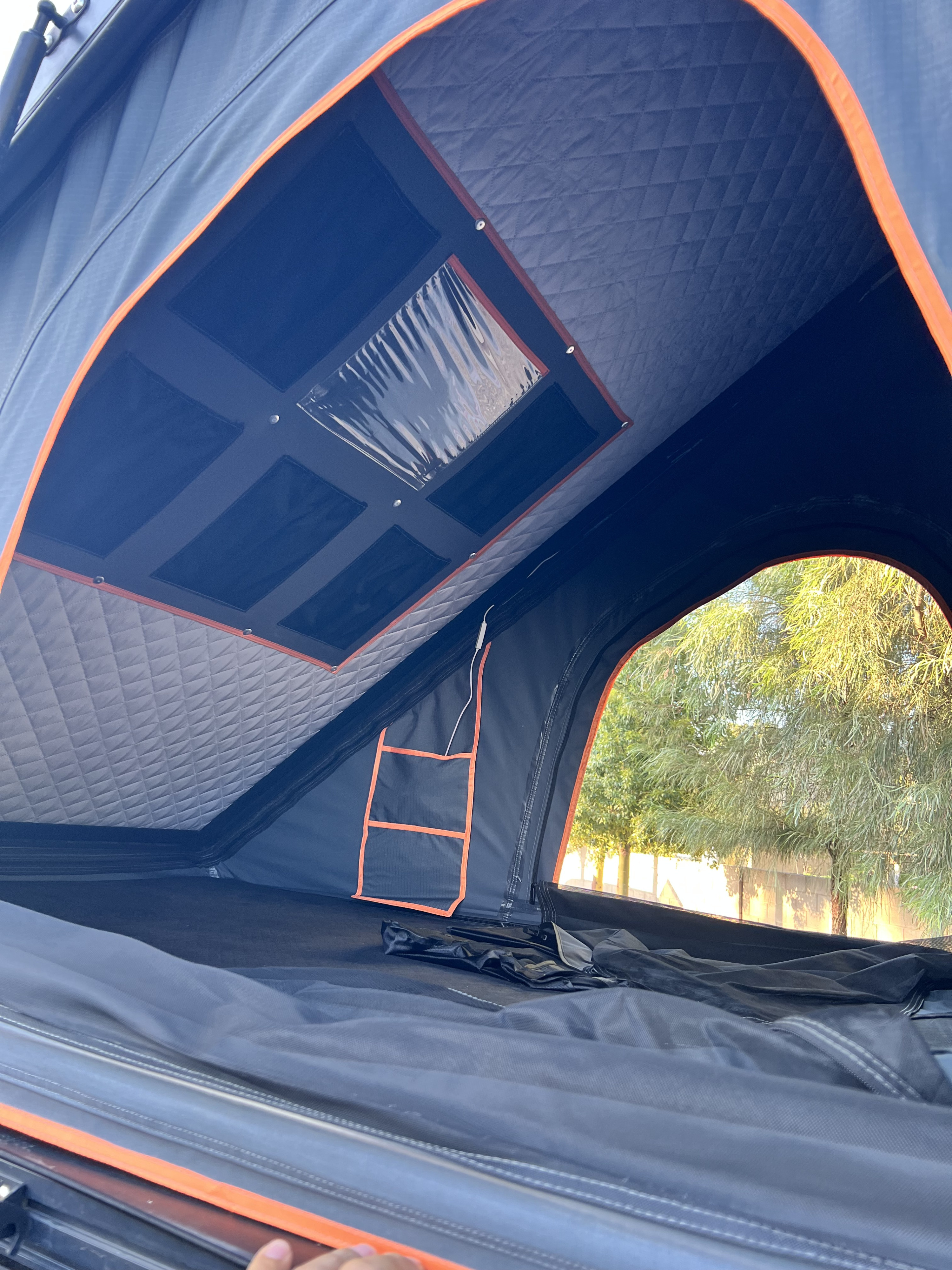 Step inside this RV rental's cozy rooftop tent! Enjoy the padded interior, clear ceiling window, and tree views.. Toyota 4Runner 2020