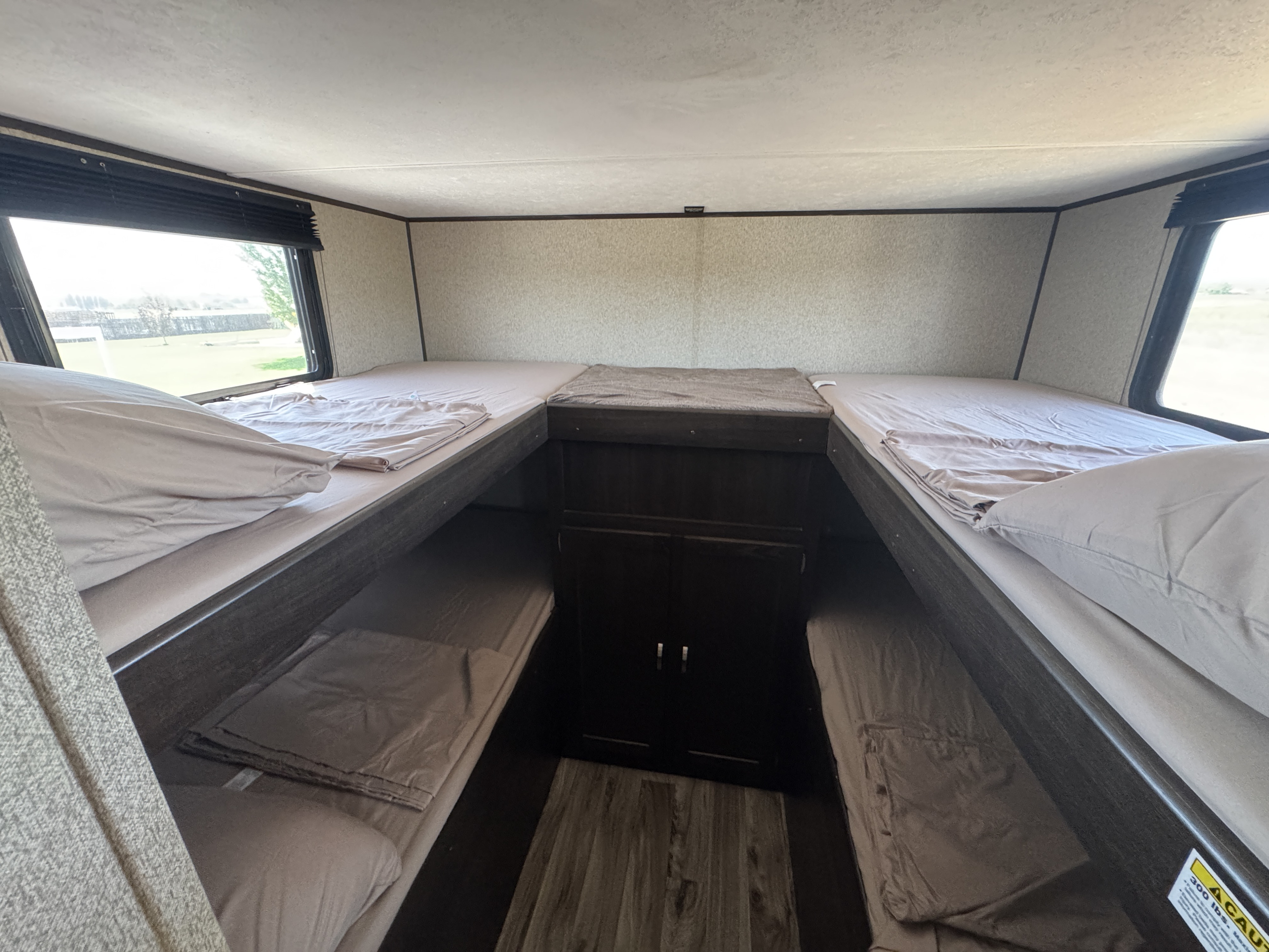 RV rental bunk room: Bright interior with two sets of bunk beds, ideal for multiple sleepers on a trip.. Keystone RV Springdale 2019