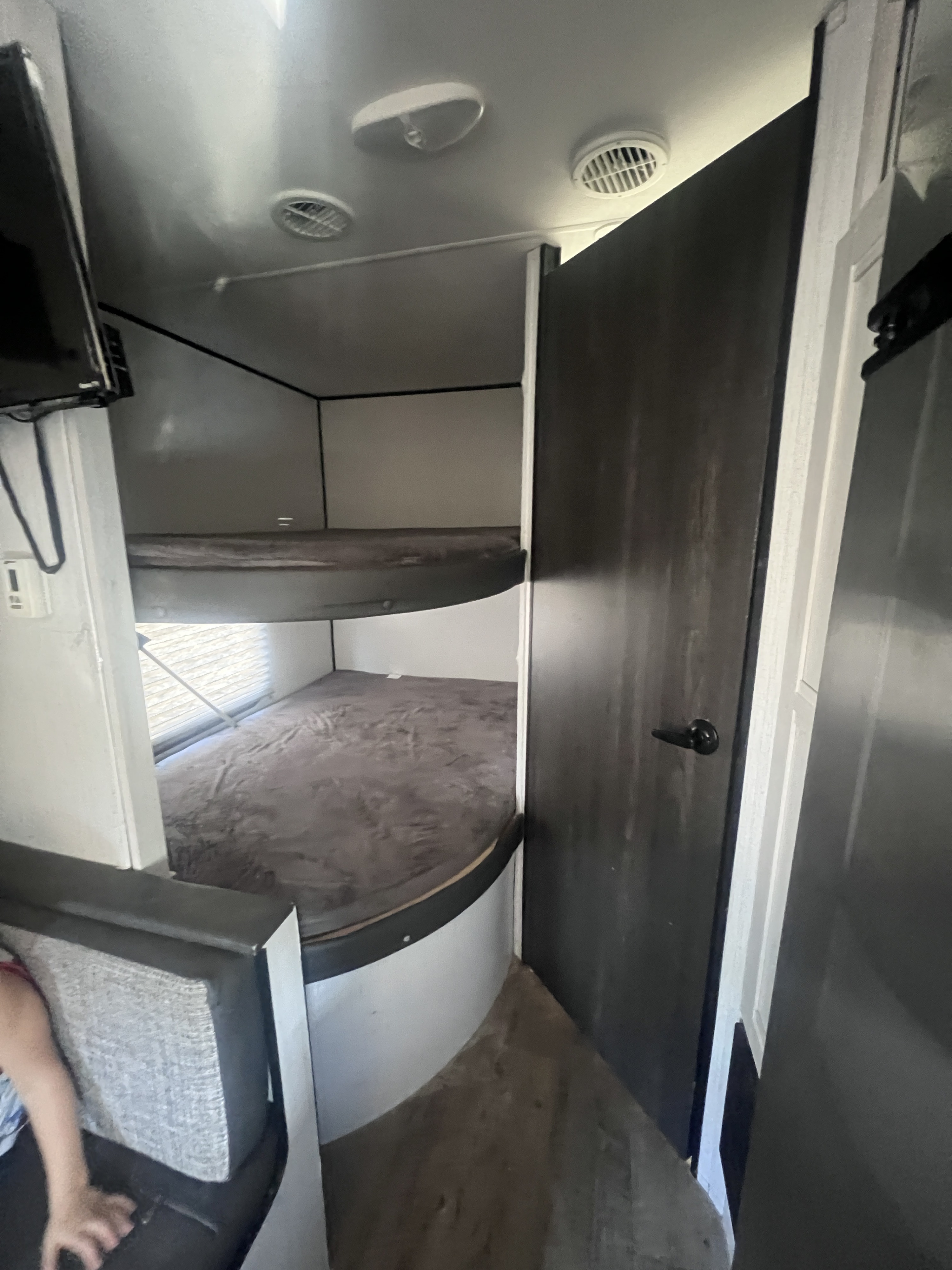 Cozy bunk beds inside an rv rental, perfect for families. Features two stacked beds with soft gray bedding.. Heartland RVs Trail Runner 2021