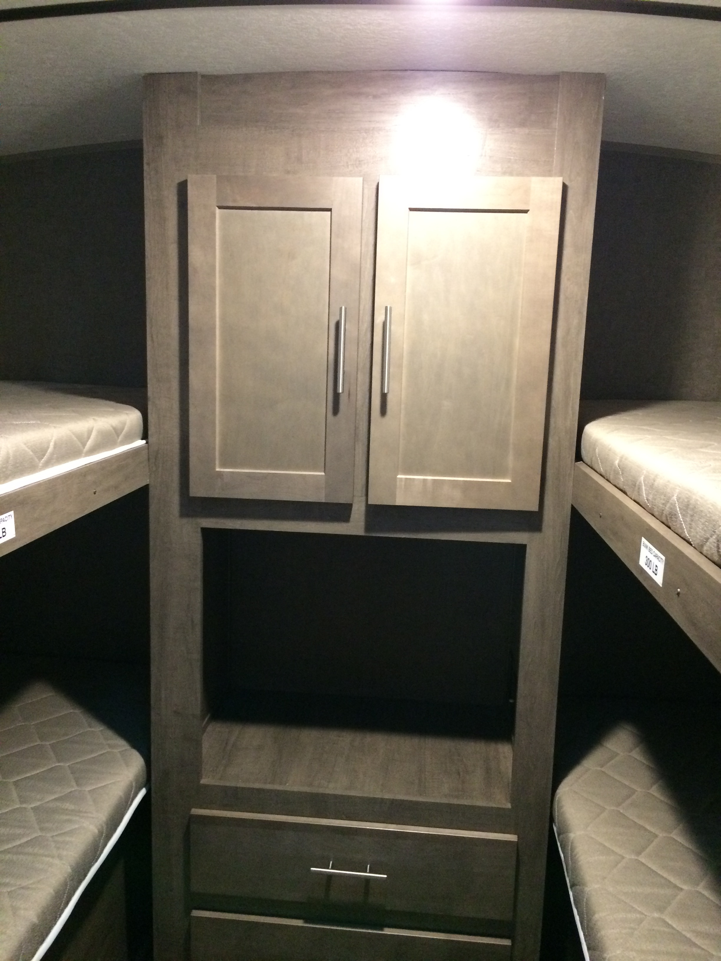 This RV rental interior shows a bunkhouse layout with a central storage unit, perfect for families.. Forest River Surveyor 2017