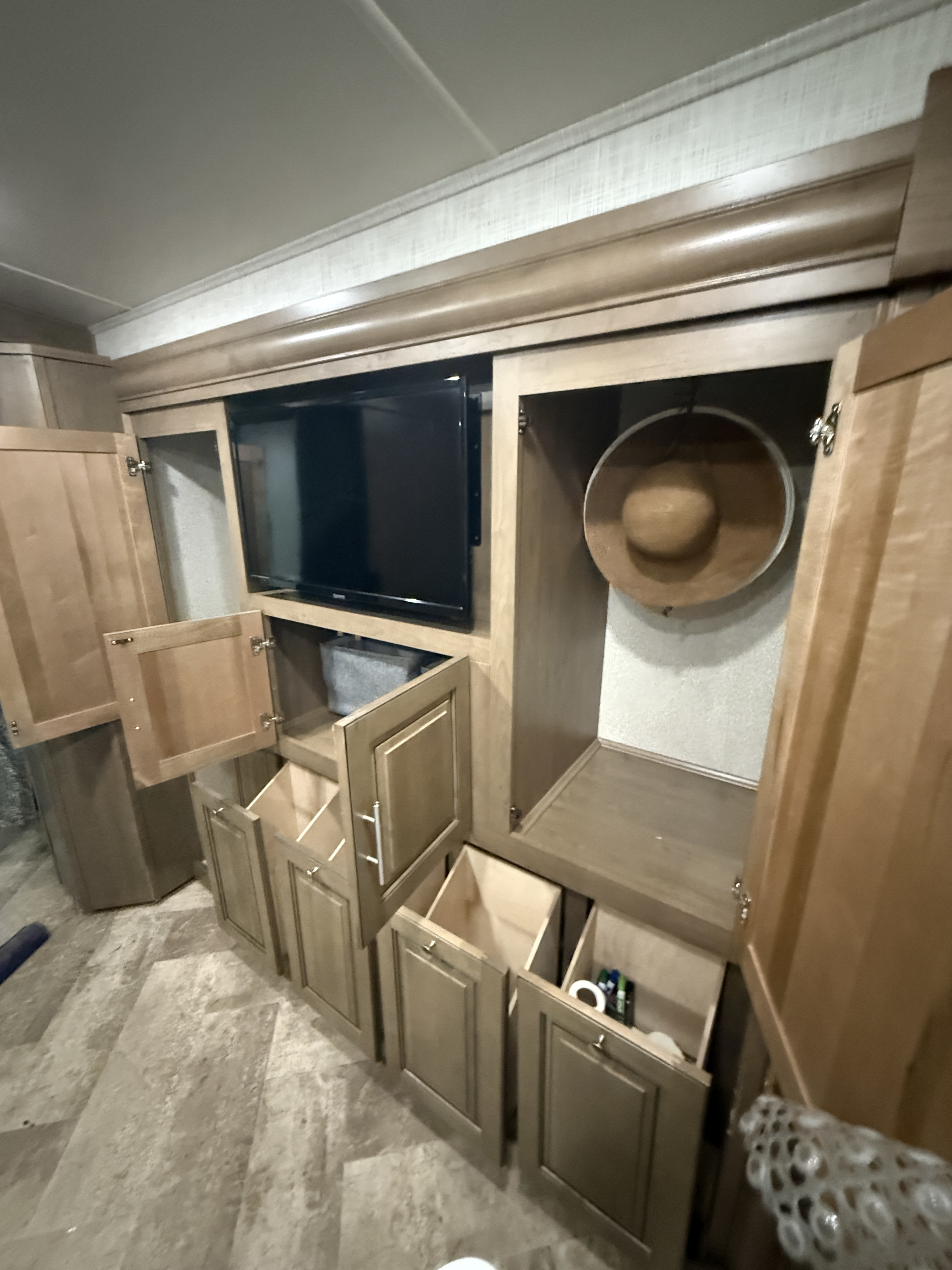RV rental interior: Built-in TV, storage cabinets, pull-out bins, and a hat neatly hung. Organized living.. Georgetown GT5 2020