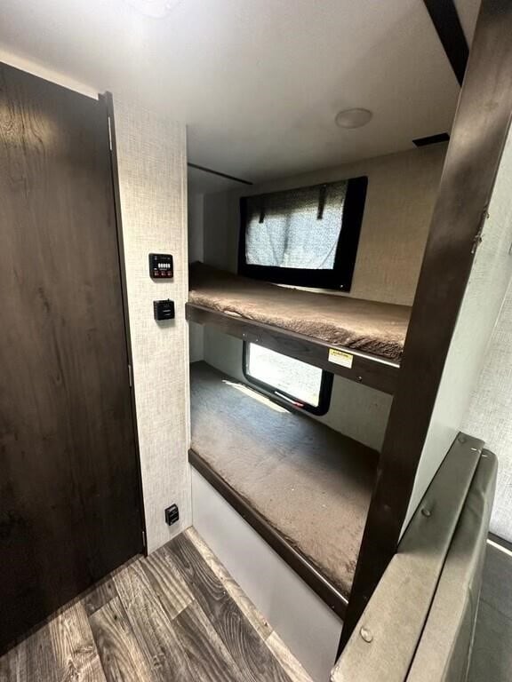 RV rental interior showcasing two bunk beds with windows and wall controls. Perfect for family camping trips.. Keystone RV Bullet Crossfire 2020