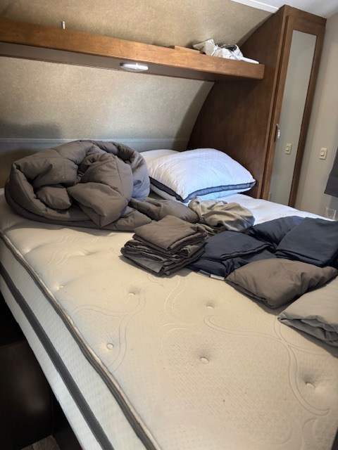 This RV rental bedroom features a clean mattress, stacked bedding, and a soft comforter, awaiting your trip.. Forest River Salem Cruise Lite 2017