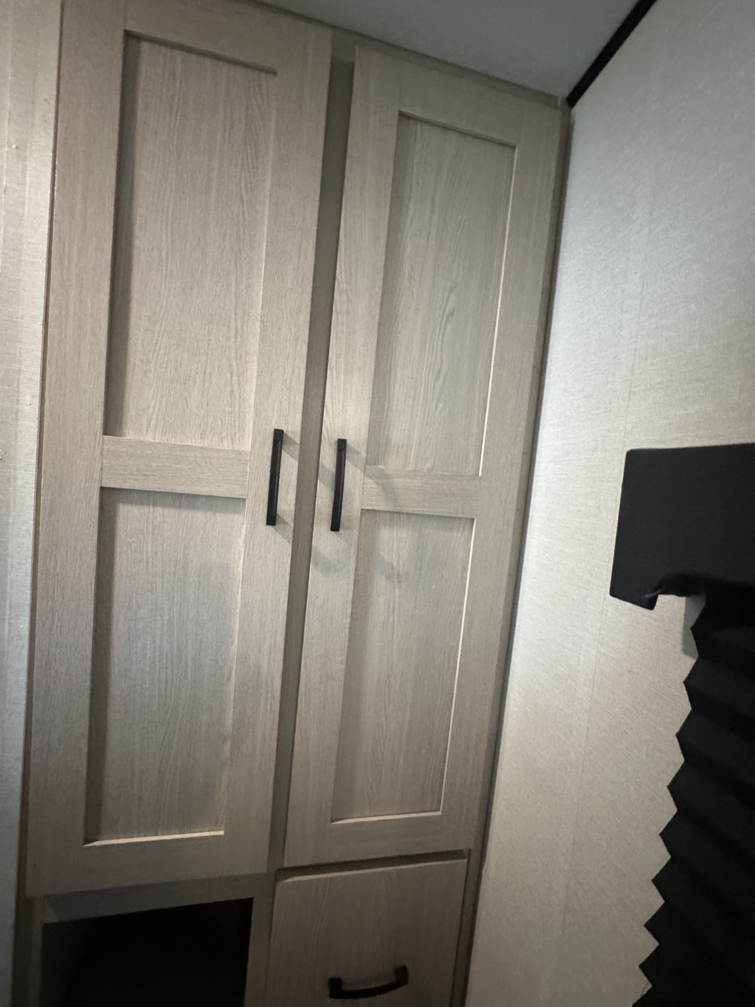 RV rental interior: Light wood cabinets with black handles, featuring doors, a drawer, and cubby storage for travel essentials.. Coachmen Apex 2022