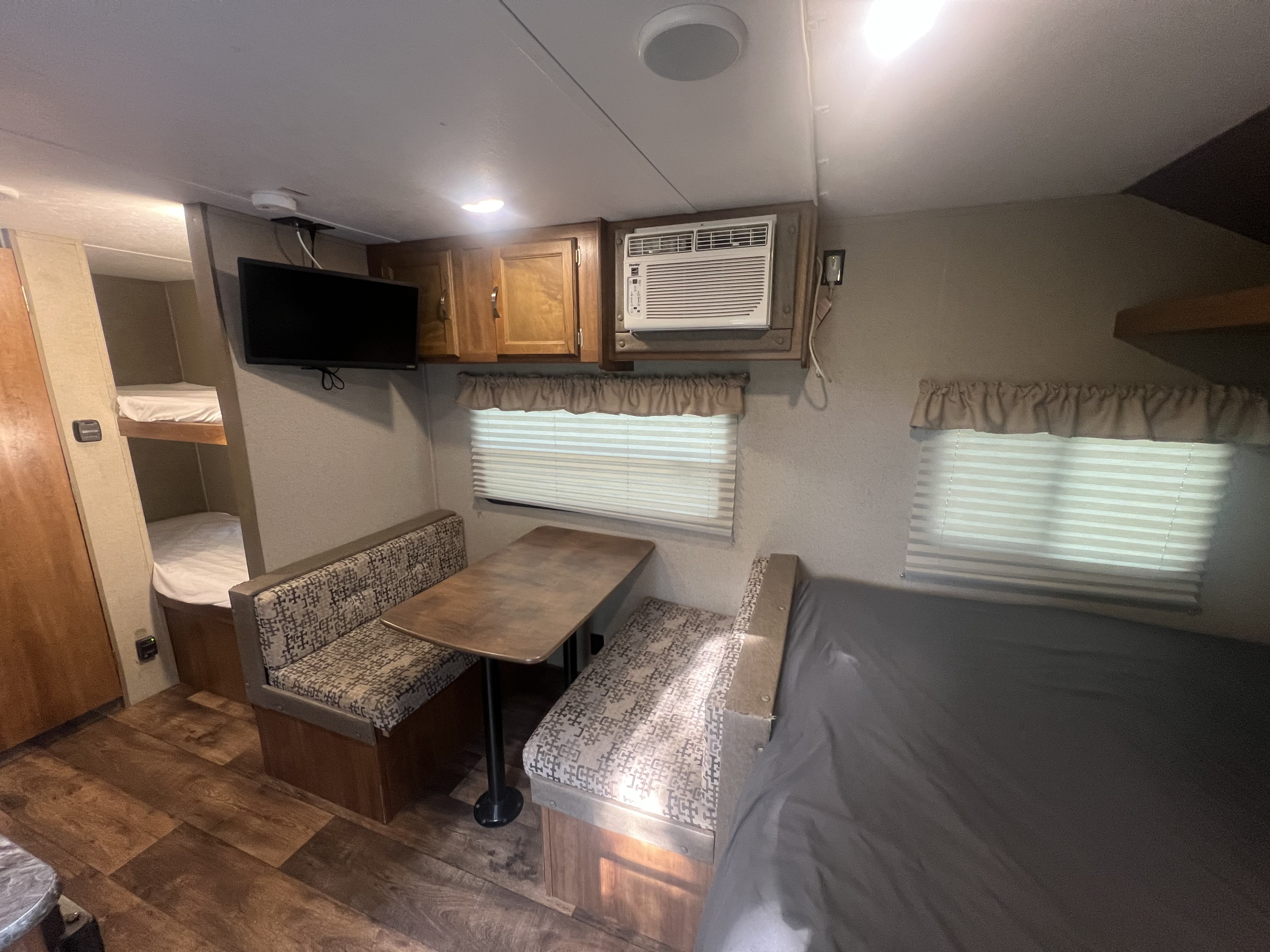 RV rental interior: A cozy dinette, bunk beds, kitchen space, and bed provide comfort for your travel adventures.. Keystone RV Summerland Mini 2017