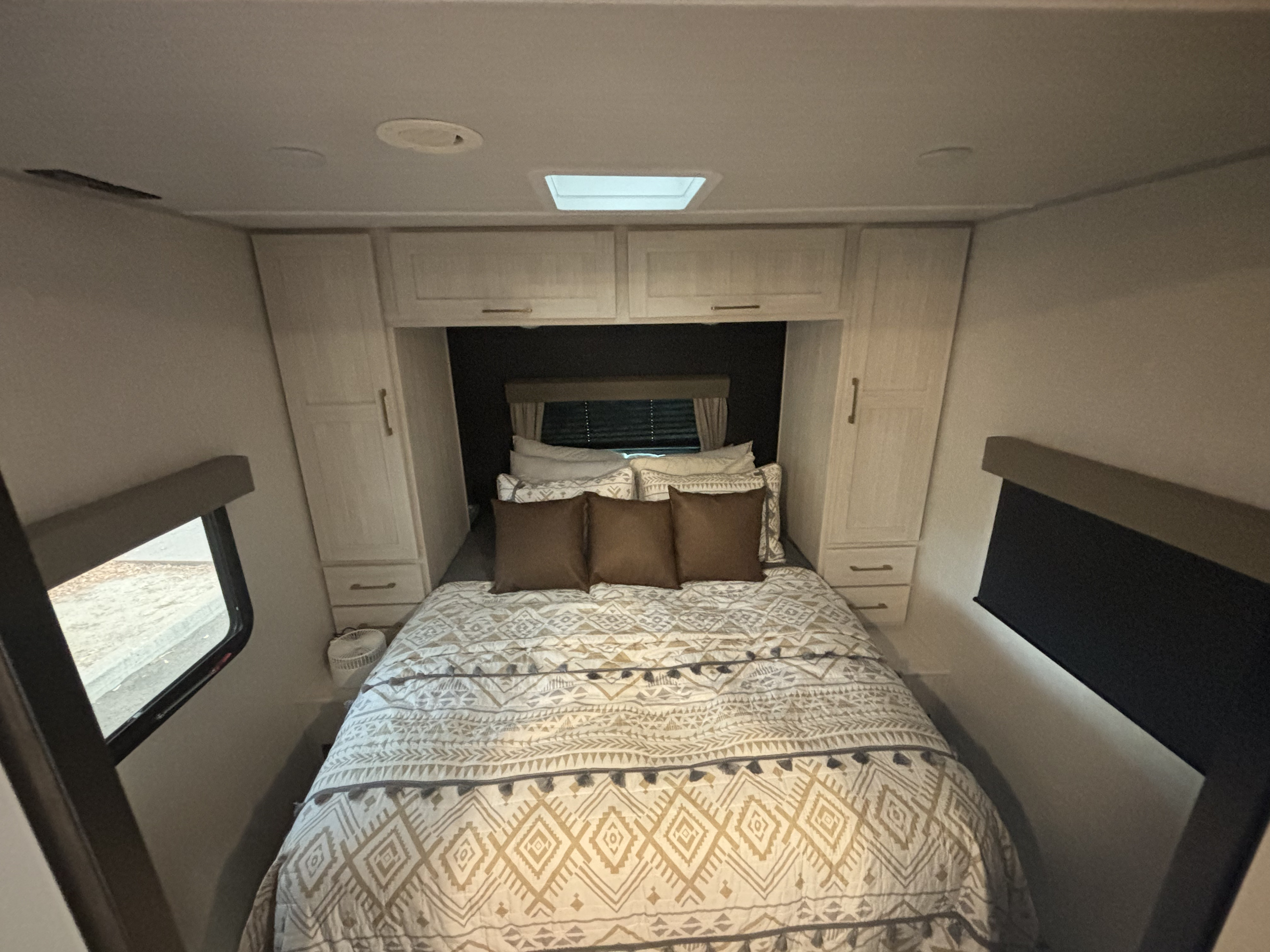 RV rental bedroom: cozy bed with storage and windows for a comfortable night's rest on your journey.. Forest River Surveyor Legend 2024