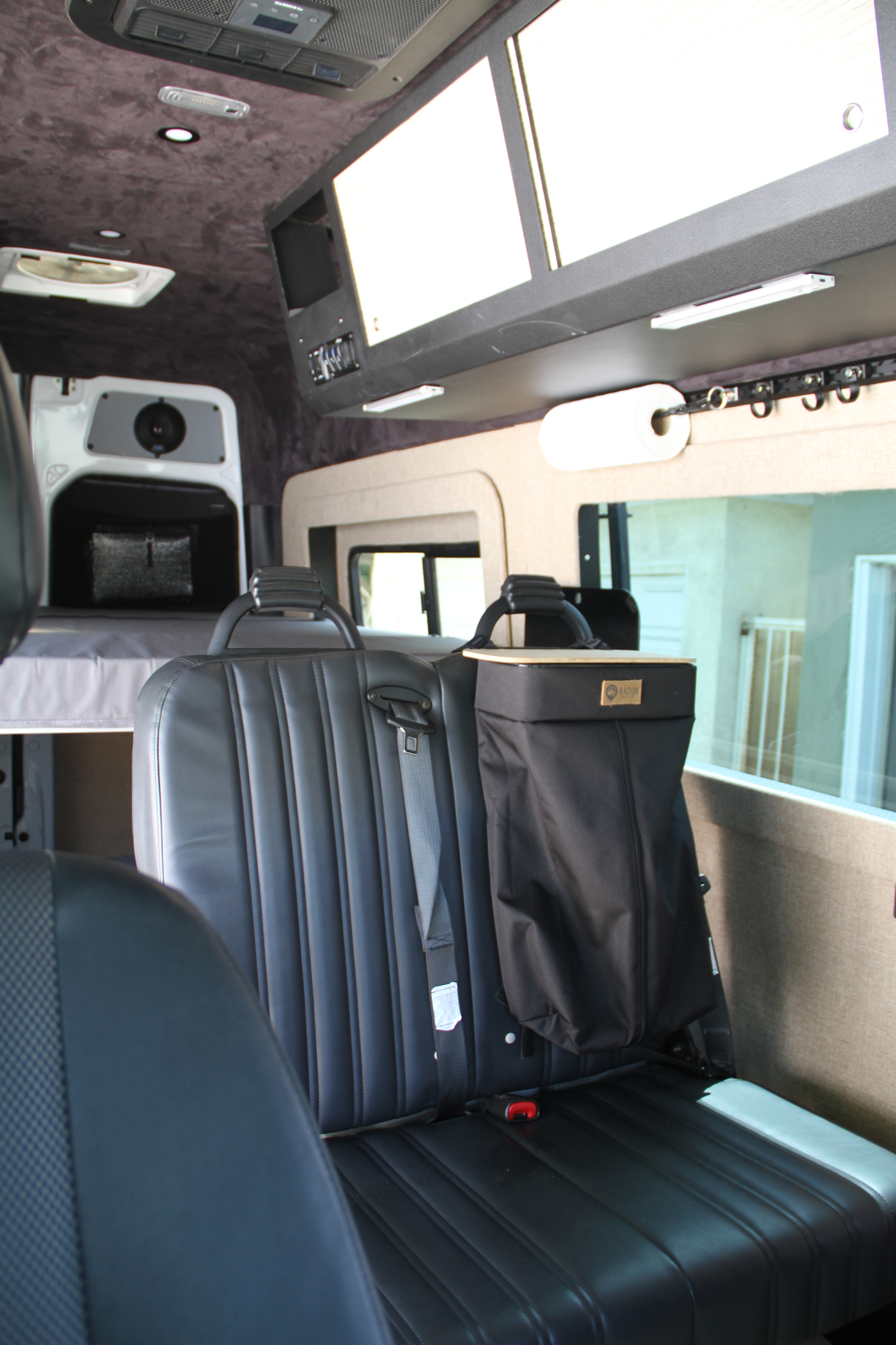 RV rental interior: black leather seats, rear bed, and overhead storage, offering comfort for your travels.. Mercedes Sprinter Sprinter 144 2017
