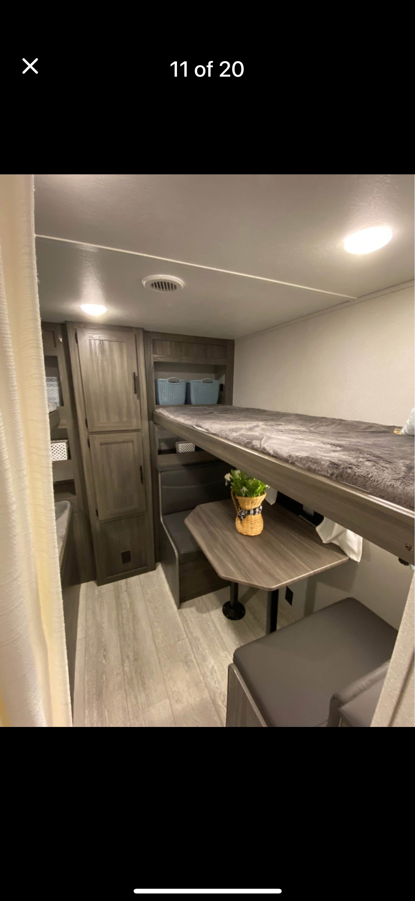 RV rental interior: A compact bunk bed sits above a small dining booth, offering efficient use of space with storage.. Forest River Shasta 2021
