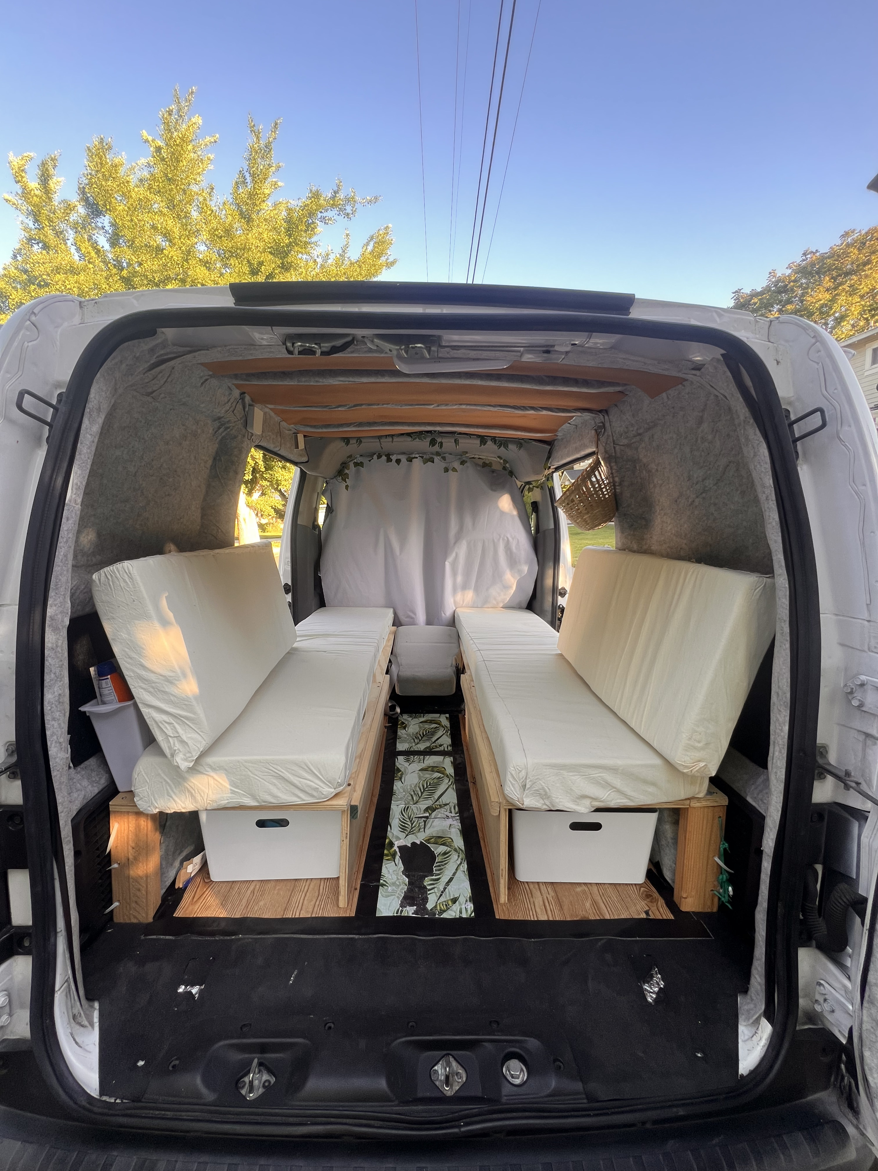 Experience adventure with this RV rental! Converted camper van interior featuring twin beds and integrated storage.. Nissan NV200 Compact Cargo 2019