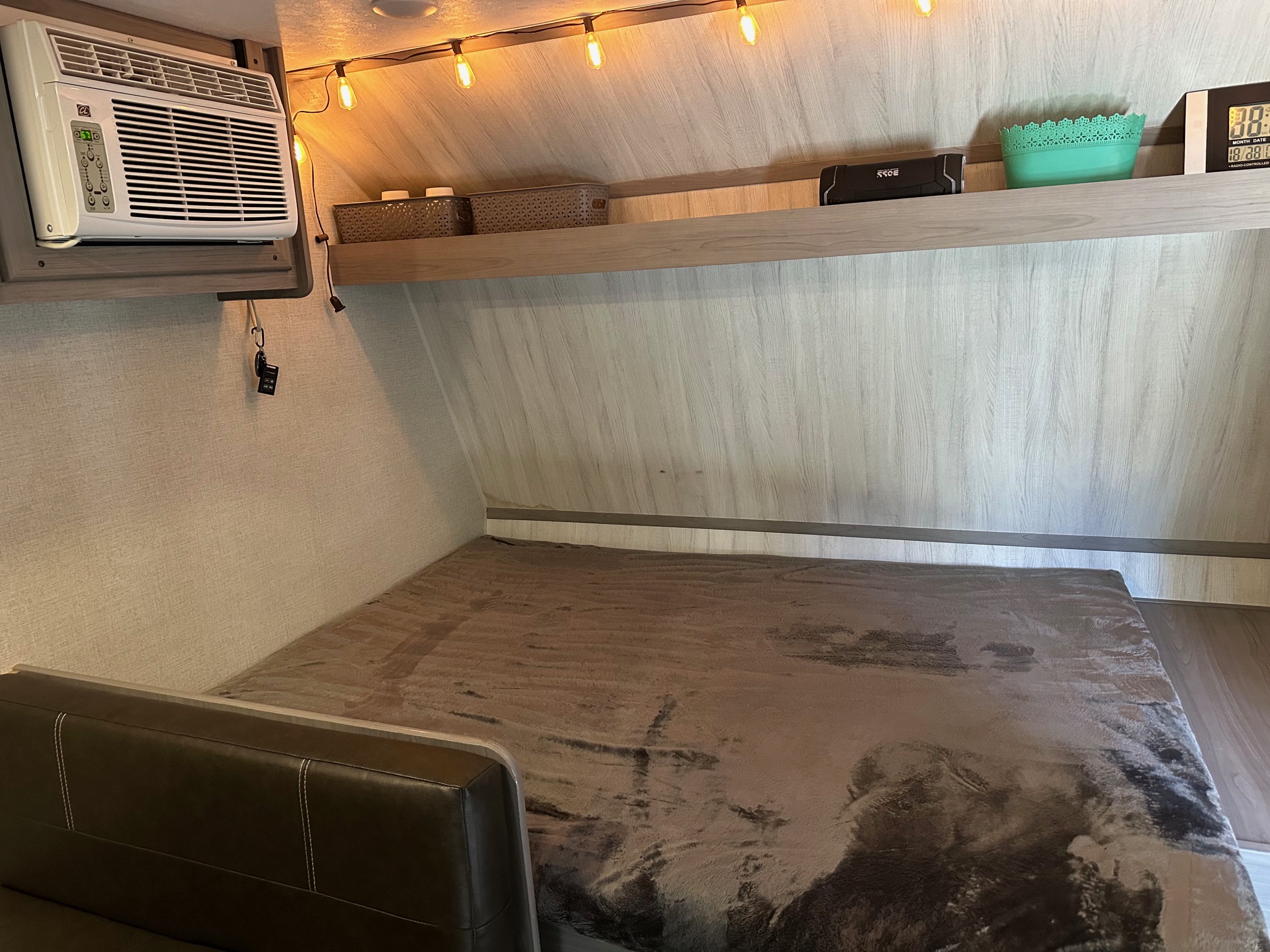 Inside an RV rental: a comfortable bunk bed with AC unit & string lights for a relaxing camper experience.. Coleman Lantern LT 17 B 2023