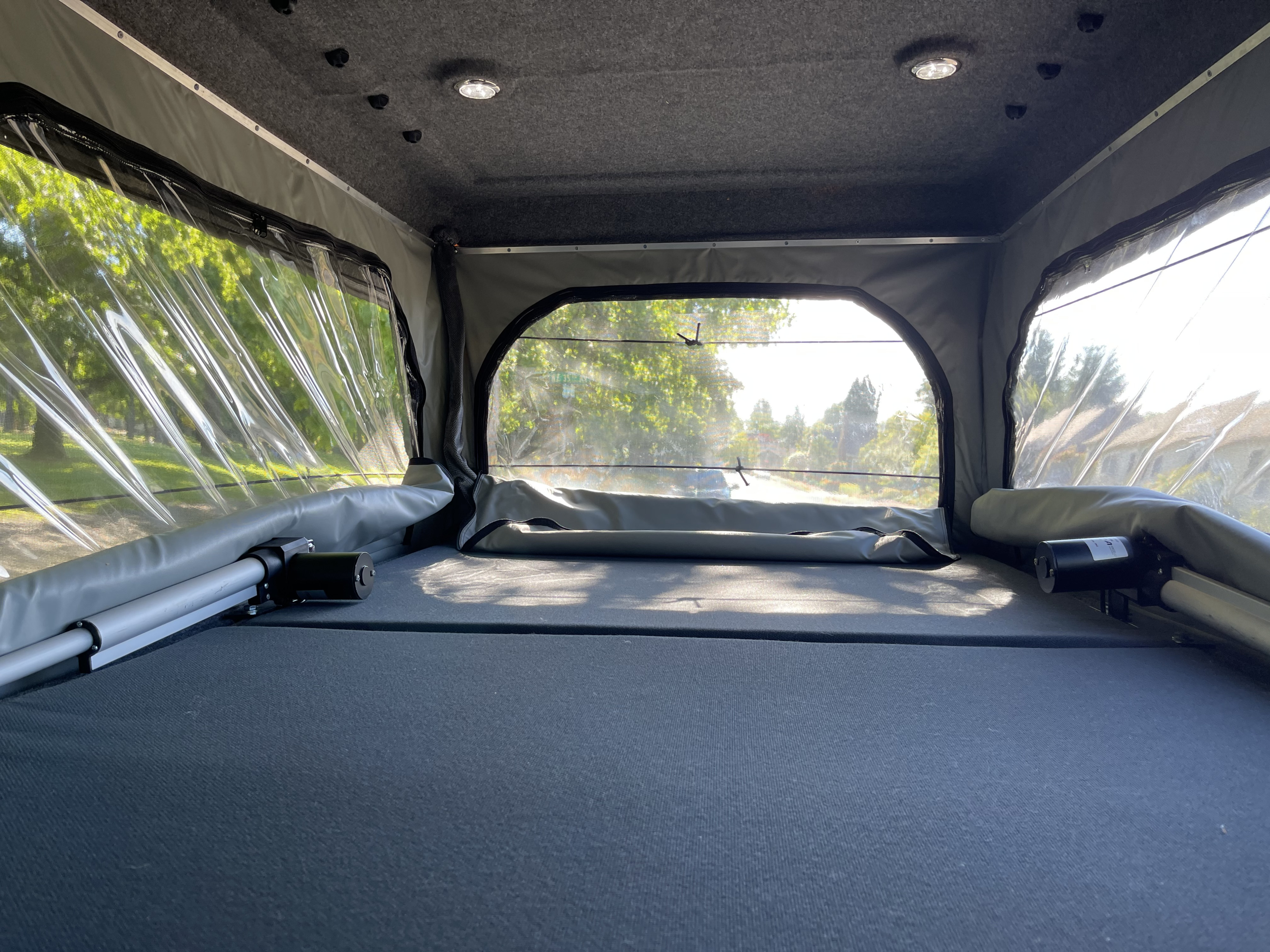 Spacious RV rental pop-top interior: clear side windows offer bright views, a soft sleeping platform, and ceiling lights.. Volkswagen Westfalia 1997