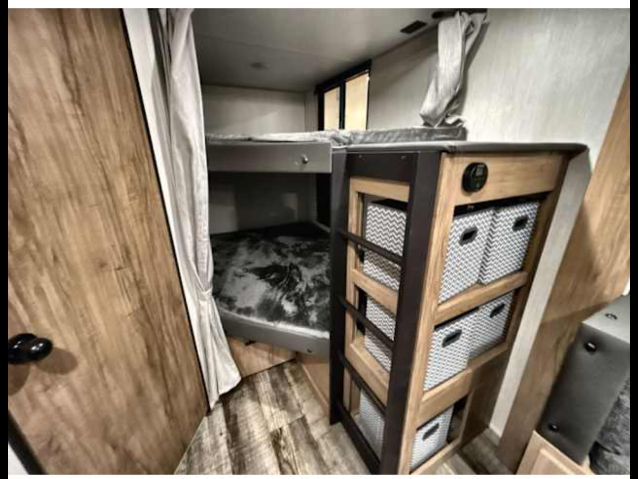 RV rental: Bunk beds, privacy curtain, and clever storage unit with patterned bins offer smart space solutions.. Forest River Campsite Reserve 26CJ 2025