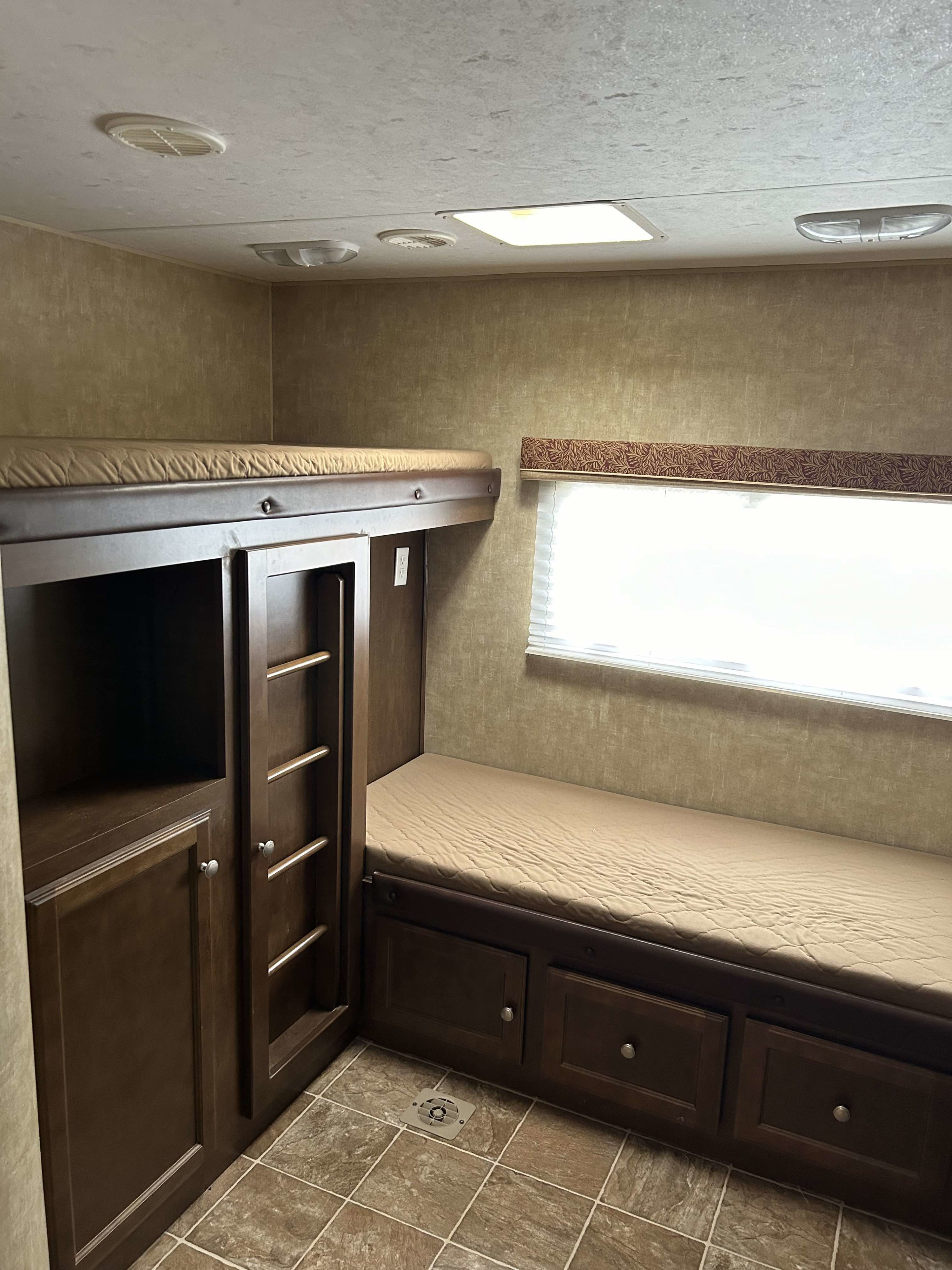 This RV rental features cozy bunk beds, lower storage drawers, and a window, providing comfortable sleeping and storage.. Sport Trek Sport Trek Trailer 2014