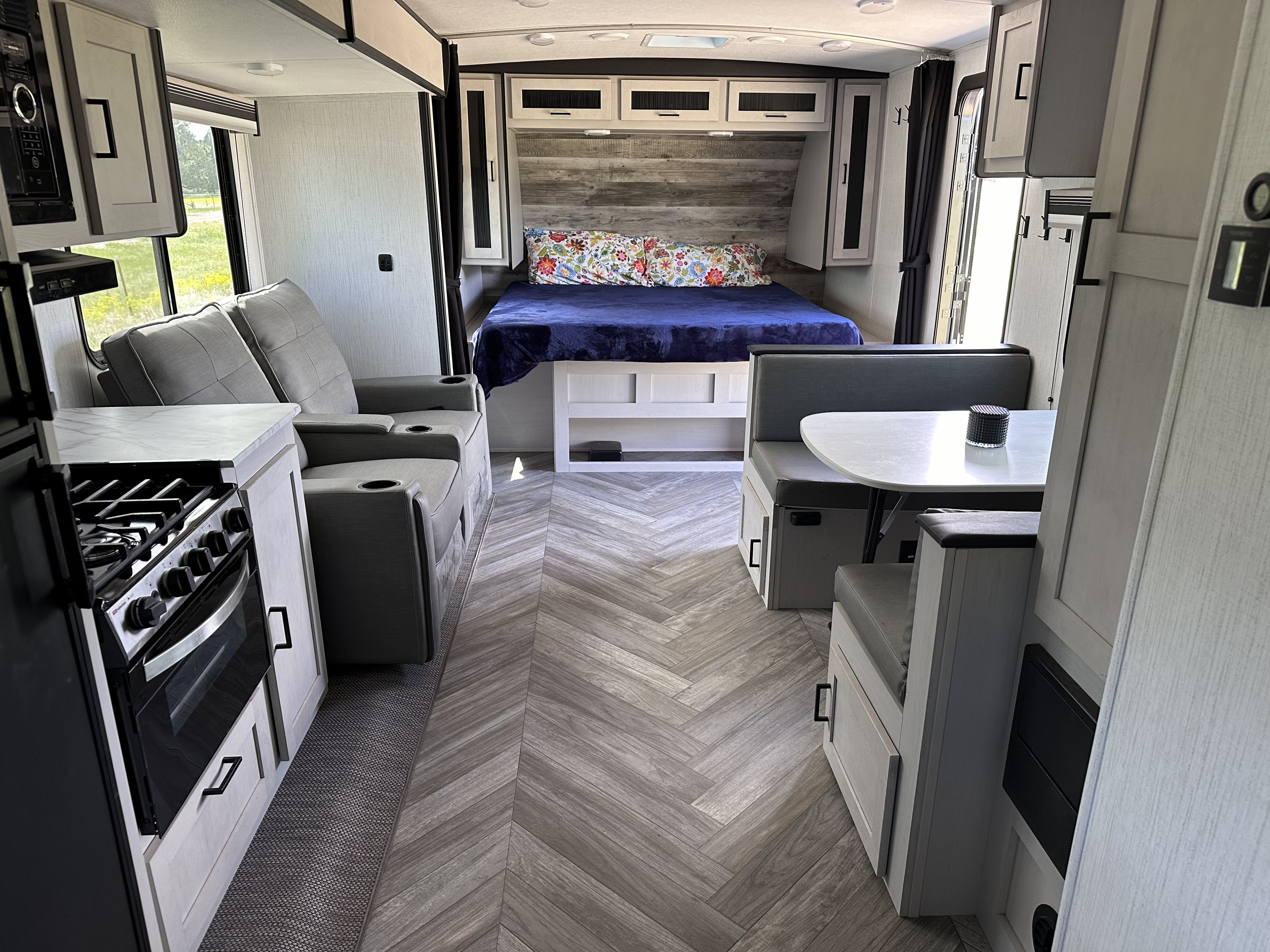 Modern RV rental interior features bedroom, kitchen, dining, and comfortable living area with recliners.. Heartland RVs Mallard 2023