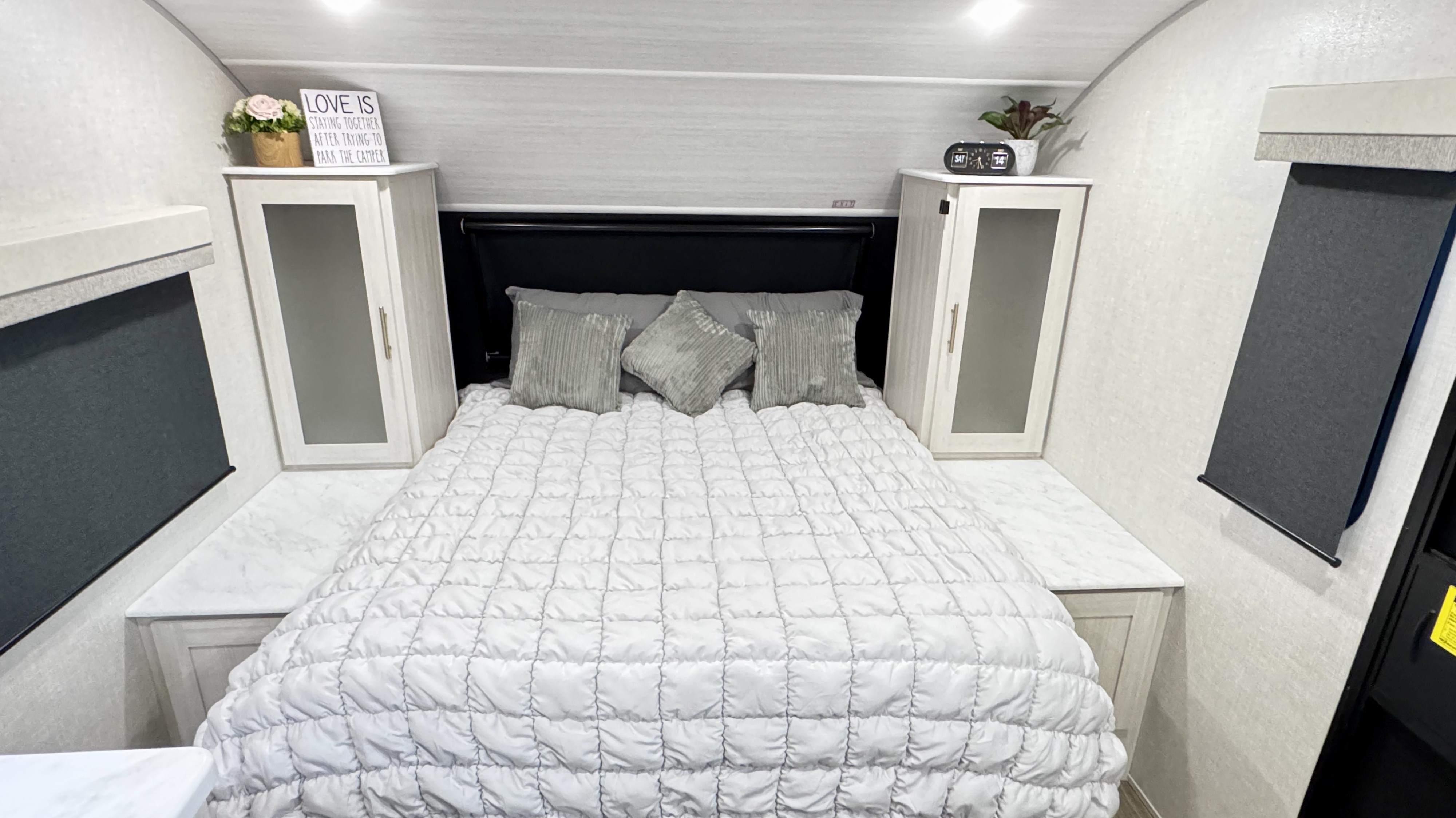Inside an RV rental bedroom: a comfortable bed, bedside cabinets, and charming decor for a cozy camper stay.. Forest River R-Pod 197 2025