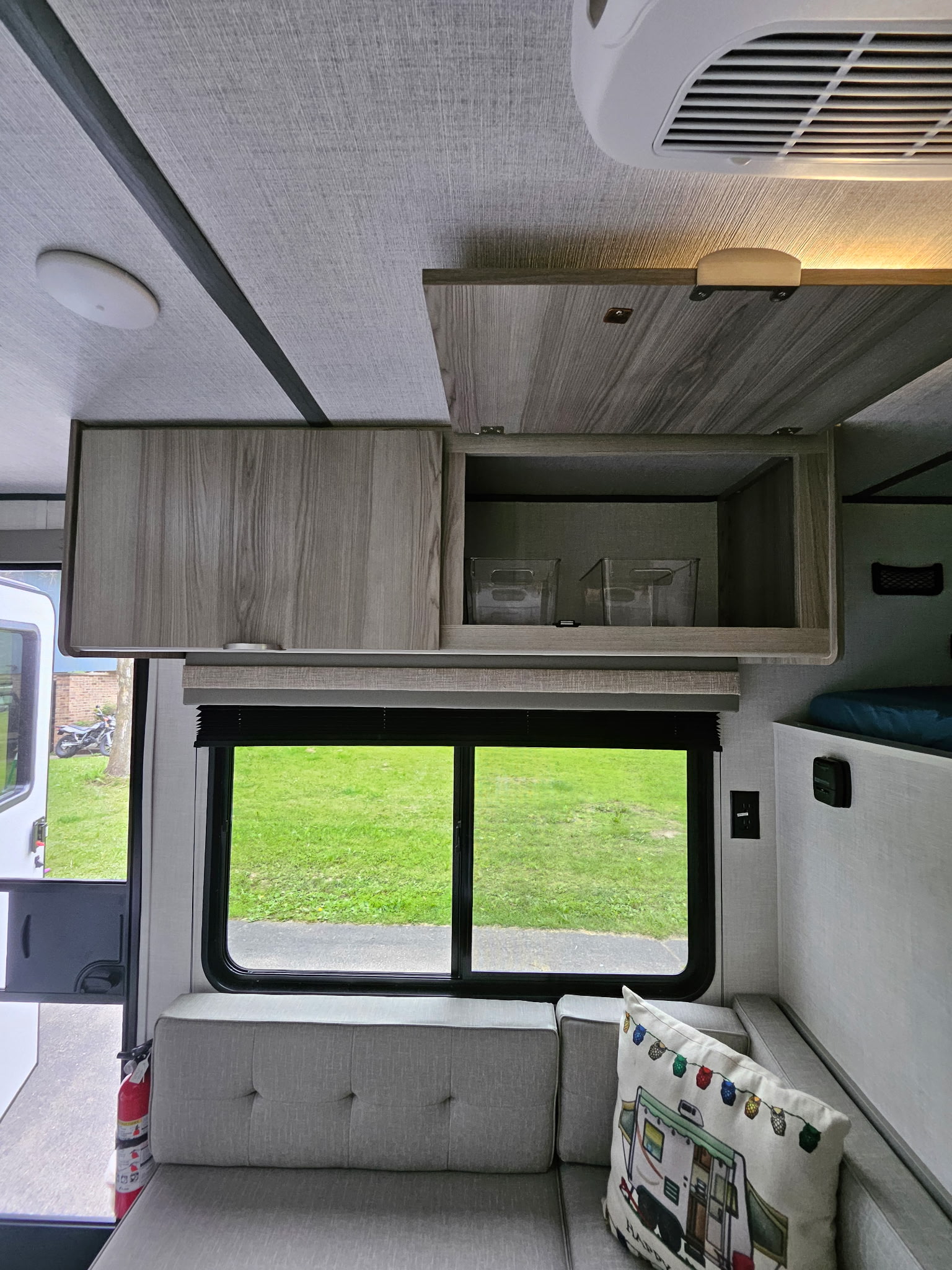 Inside a modern RV rental: ample overhead storage, comfy seating, and a window view of the outdoors.. Forest River Salem 174dble 2025