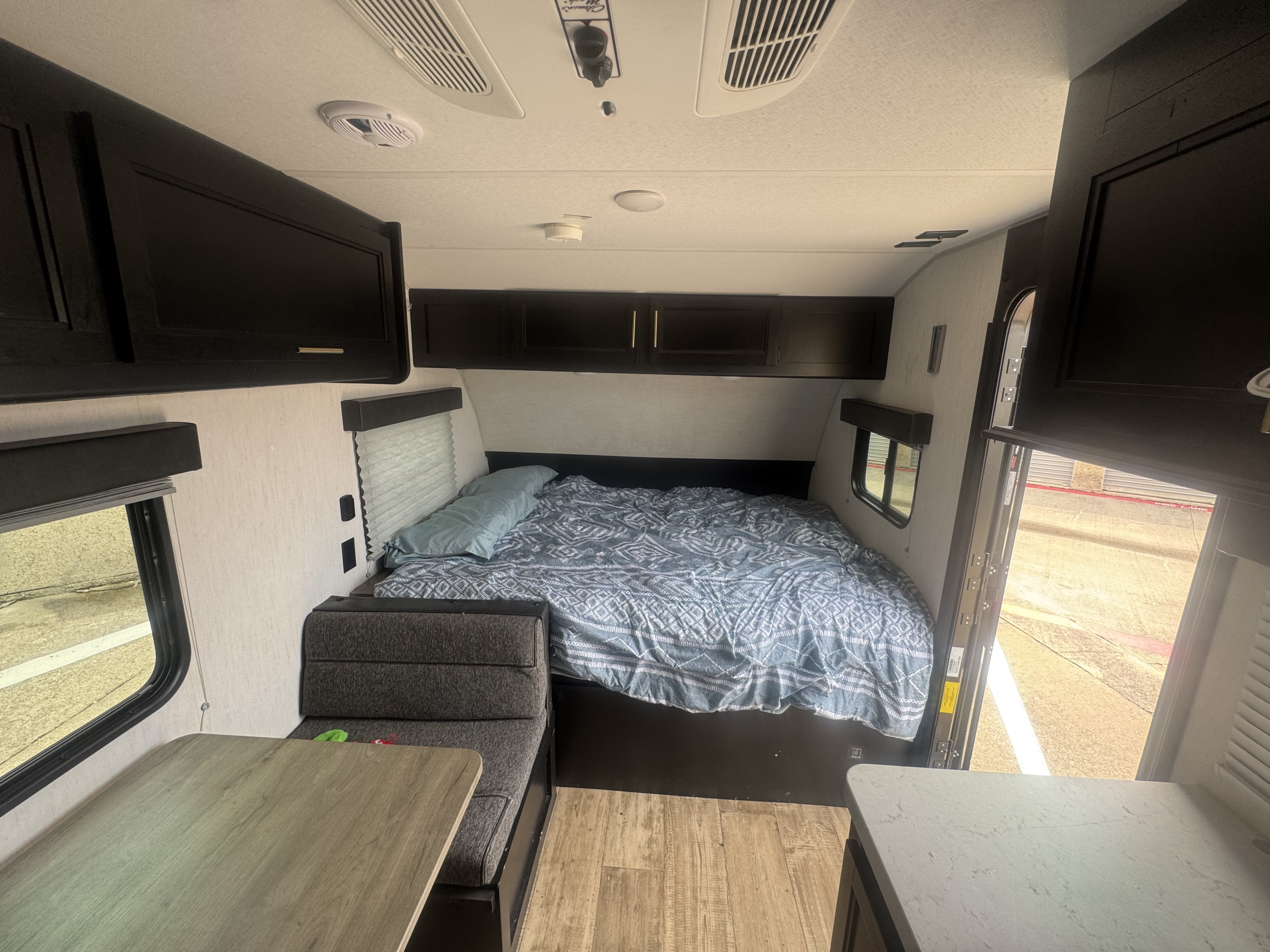 Inside an RV rental: a compact interior with a bed, dining area, and ample storage for comfortable travel.. Forest River Cherokee Wolf Pup 2022