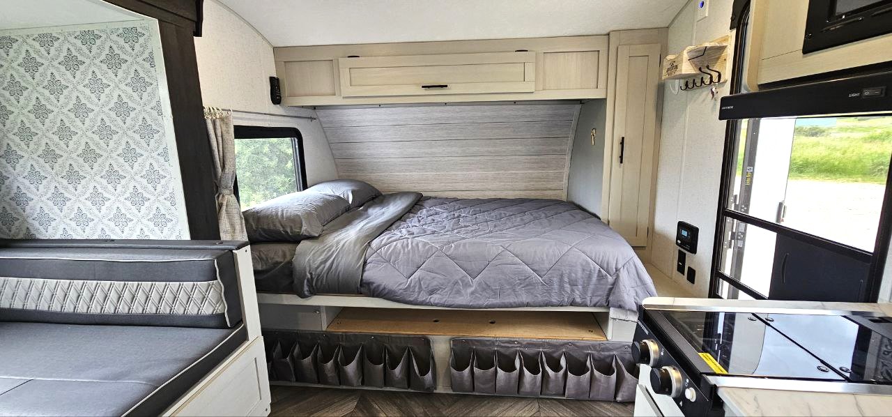 Cozy RV rental interior showcasing a bed, kitchen, and seating. Perfect for your next adventure.. Forest River Wildwood FSX 2022
