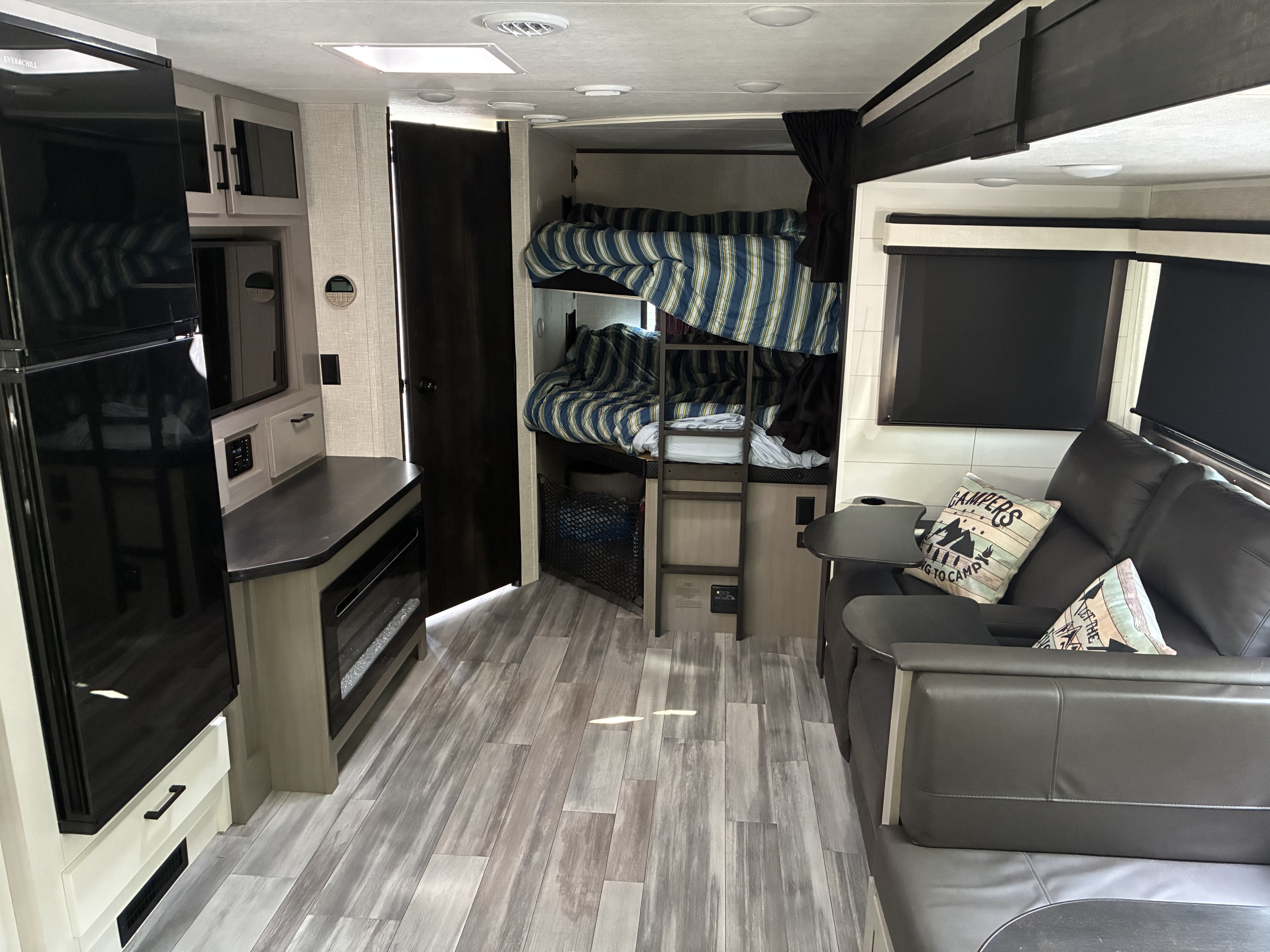 Modern RV rental interior: kitchen, bunk beds, and a comfy sofa. Ideal for families seeking adventure and relaxation on the road.. Jayco Jay Feather 2024