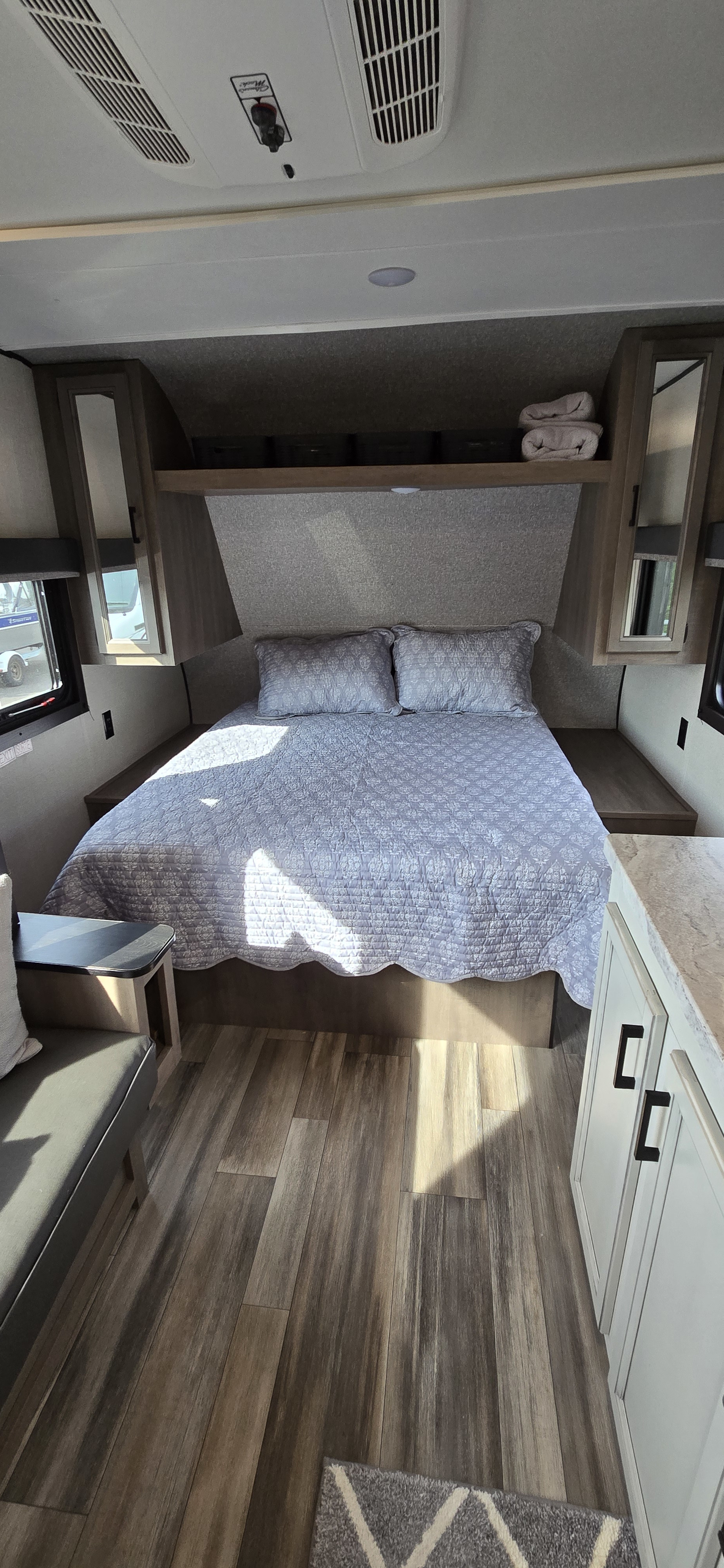 Experience comfort in this RV rental's bedroom, featuring a queen bed, overhead storage, and natural light.. Highland Ridge RV Open Range 2022