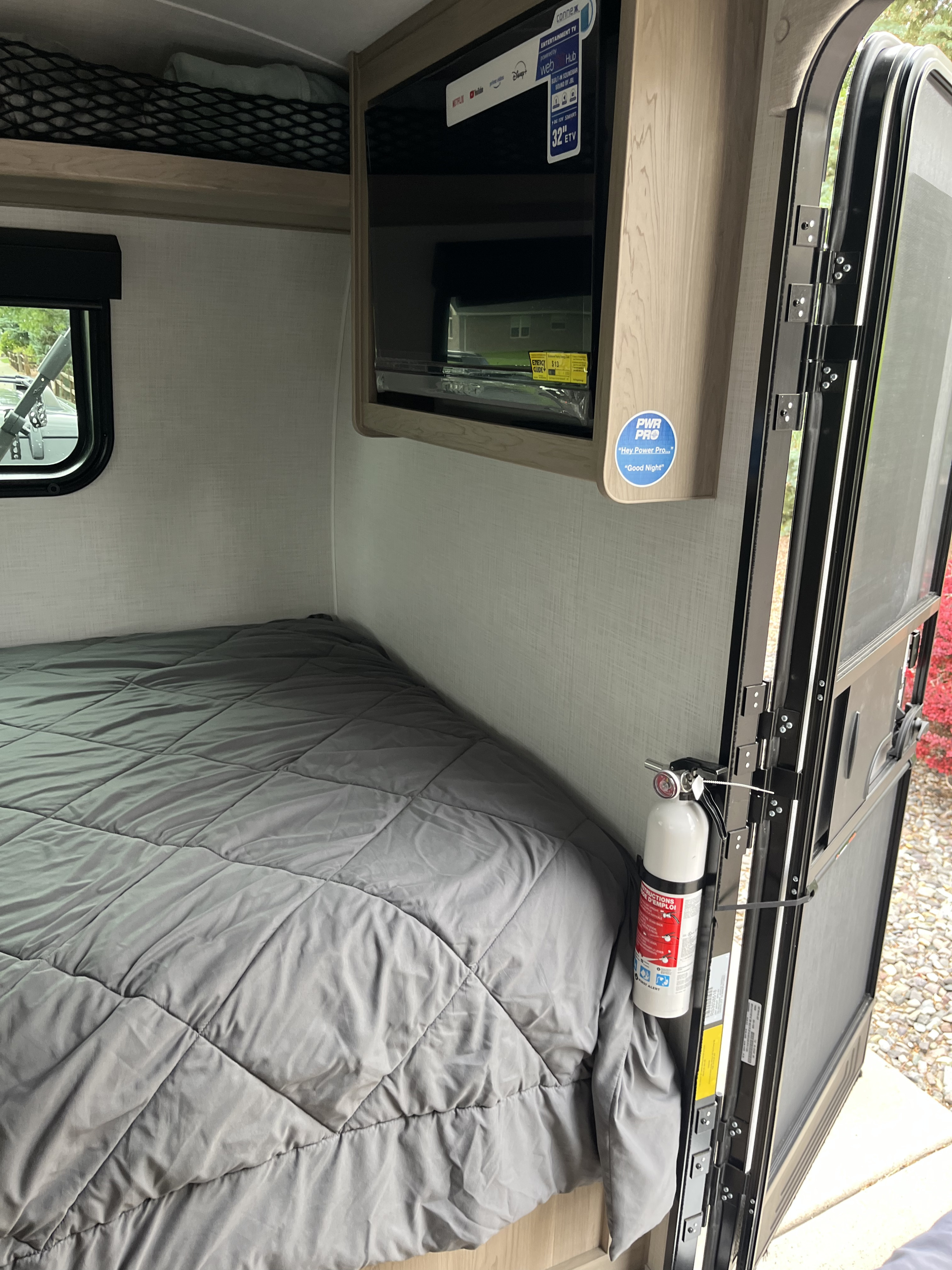 Cozy RV rental interior featuring a bed, mounted TV, and a visible fire extinguisher for safety and comfort.. Forest River Geo Pro BH20 2025