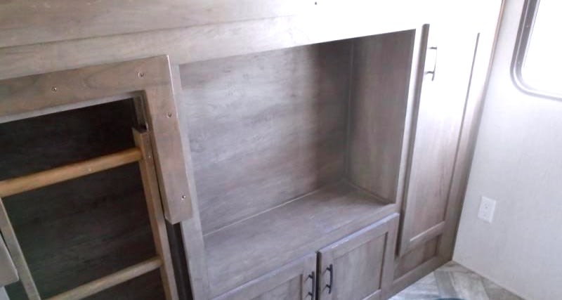 Inside an RV rental: bunk beds with ladder, storage shelving, and a wardrobe for a comfy stay.. Forest River Evo 2022