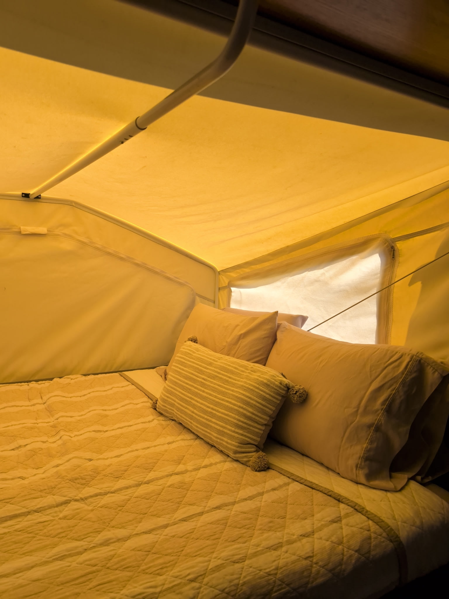 Relax in this comfortable RV rental bed! Features quilted bedding, pillows, and bright pop-up tent walls with a screened window.. Forest River ROO 2013