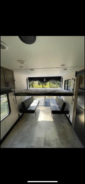 This RV rental interior shows a power bunk bed above convertible seating. Perfect for adventure or extra sleeping.. Forest River Vengeance 2021