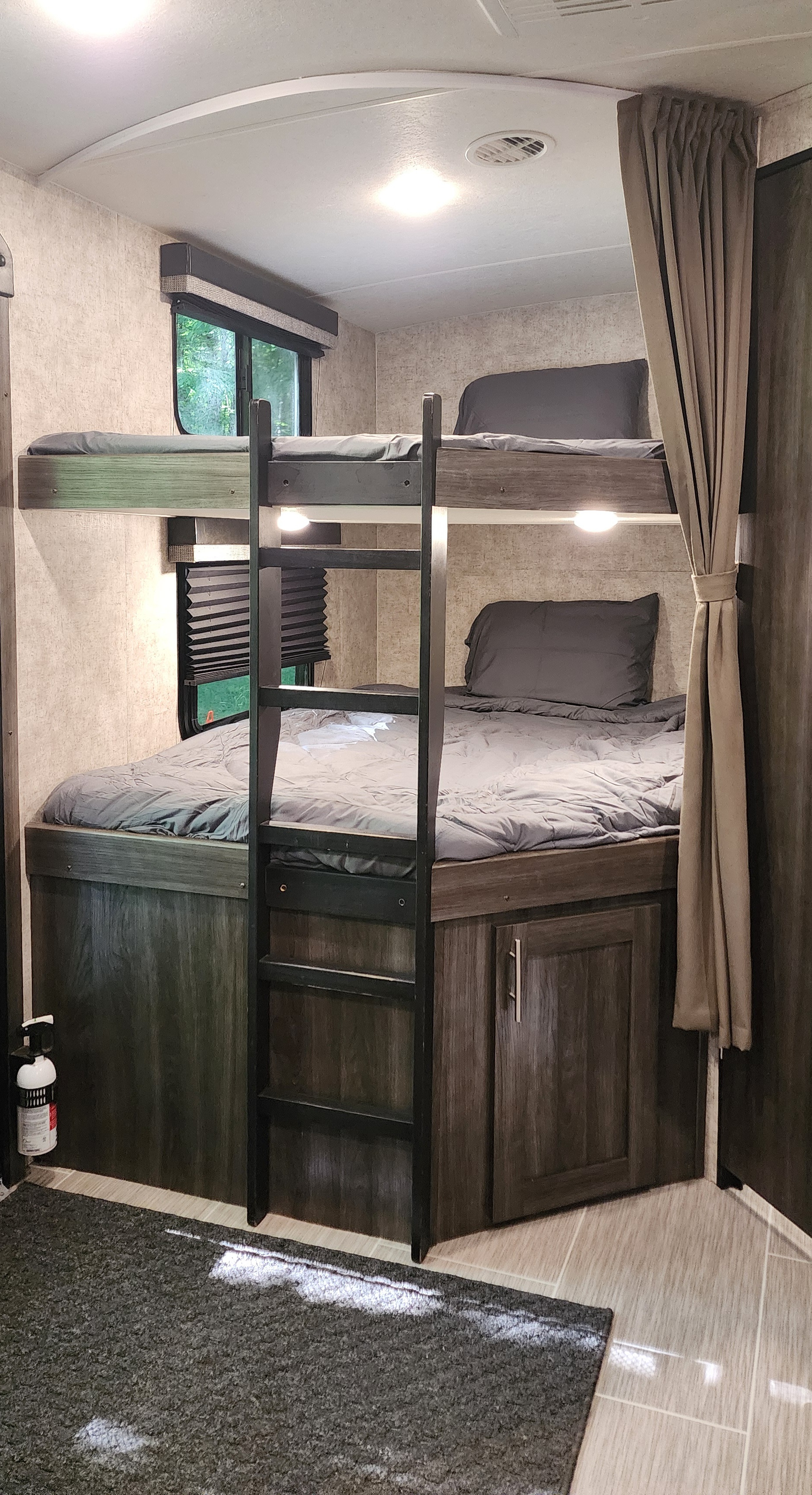 Cozy RV rental bunk beds, fully made with gray linens. Features a ladder, window, and lower storage.. Highland Ridge RV Mesa Ridge Lite 2018
