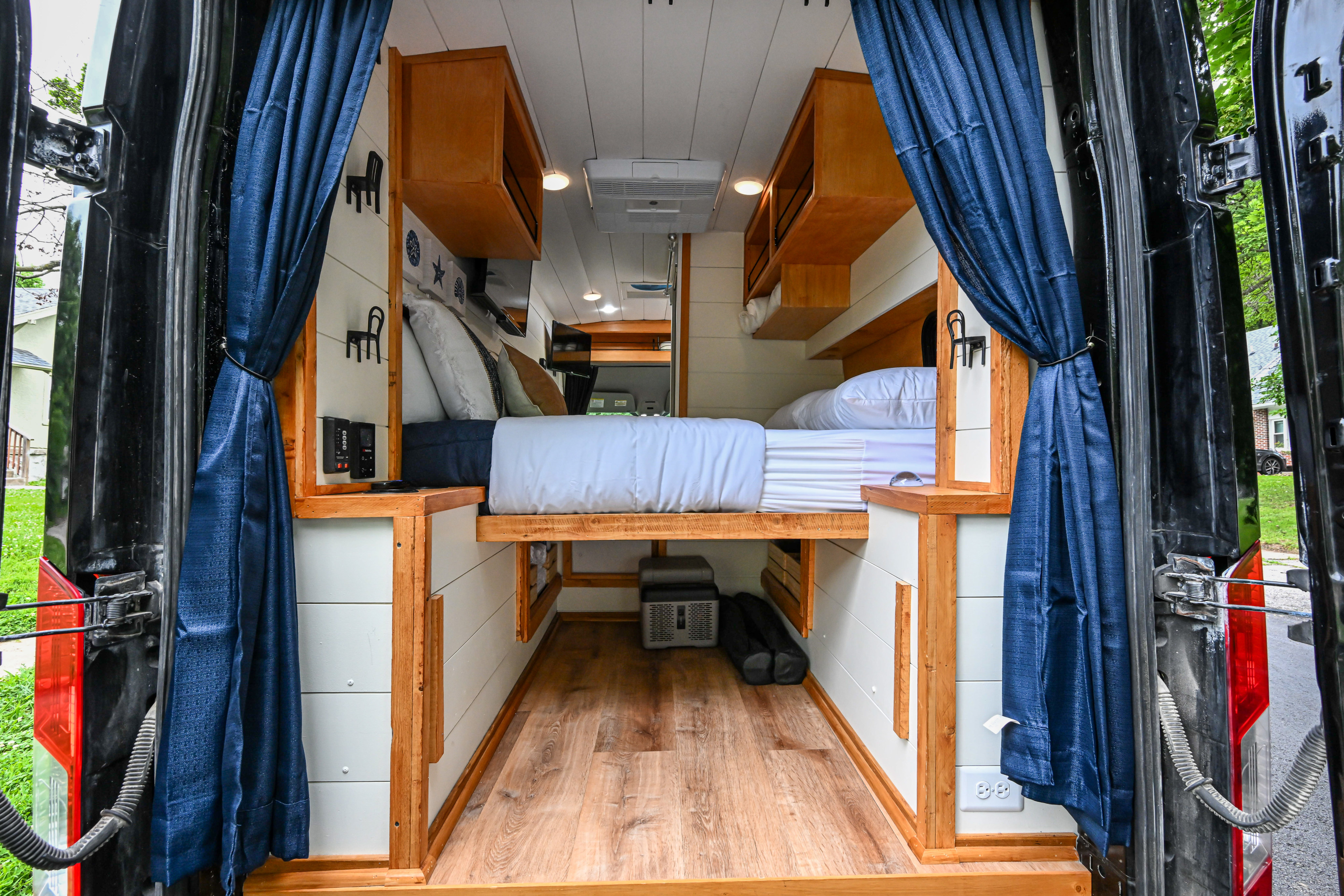 Inside this RV rental: a modern camper van conversion with a comfortable bed, smart storage, and cozy amenities.. Ford Transit 2022