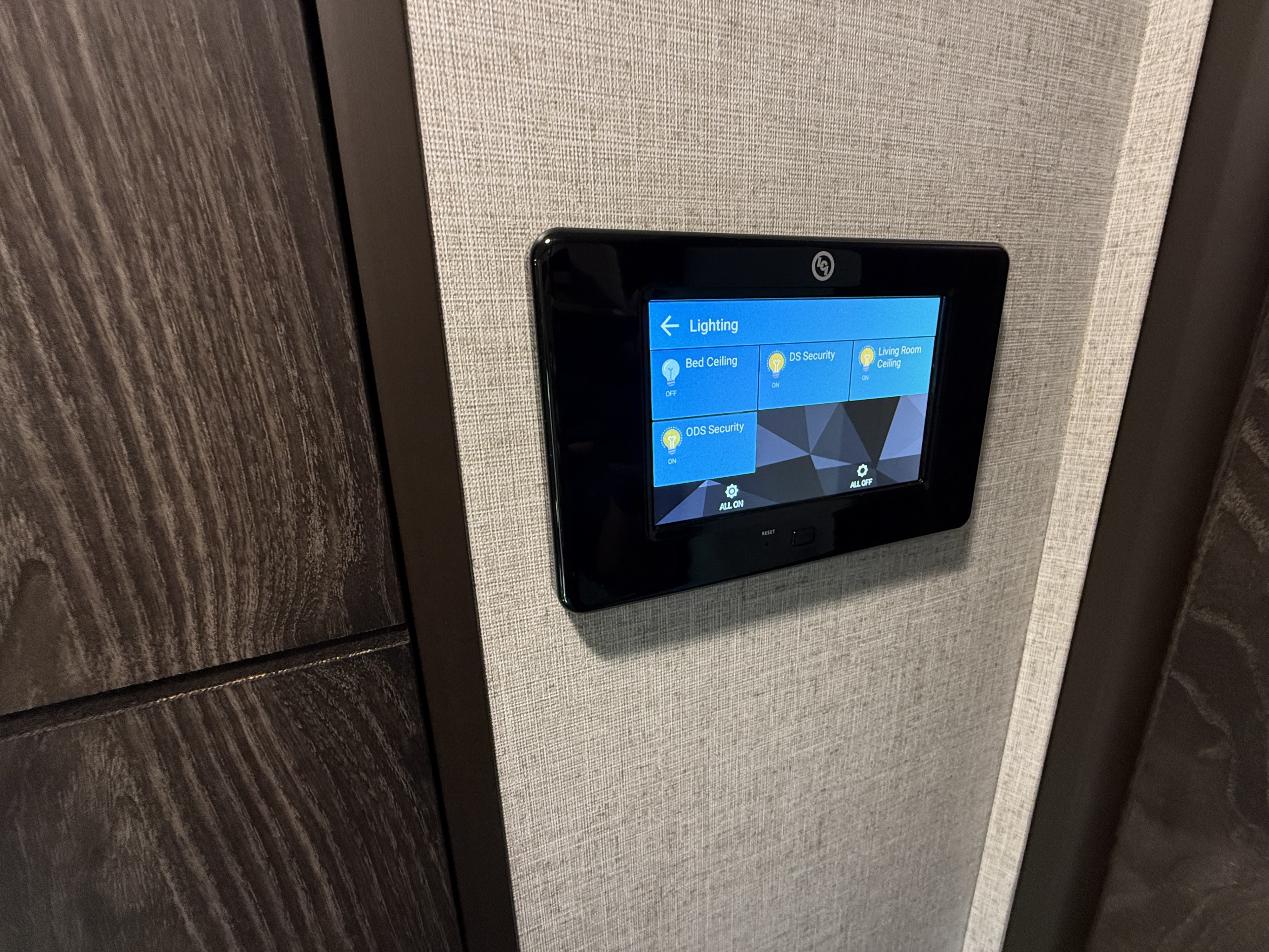 Smart control panel in an RV rental for managing lighting (Bed/Living Room) and security systems.. Highland Ridge RV Open Range 2020
