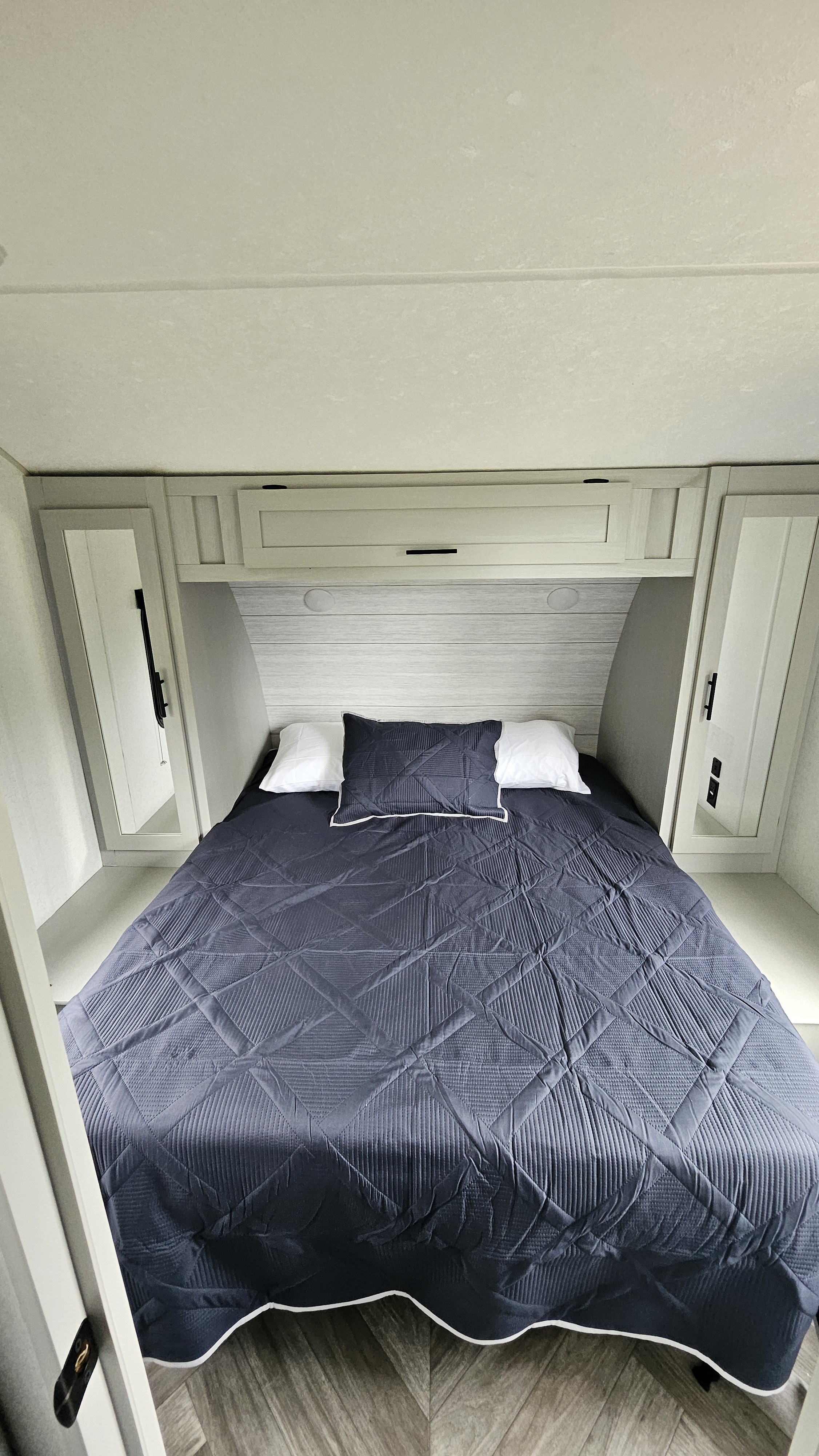 This RV rental bedroom offers a cozy bed, overhead cabinets, and mirrored wardrobes, perfect for your next trip.. Forest River Salem 2022