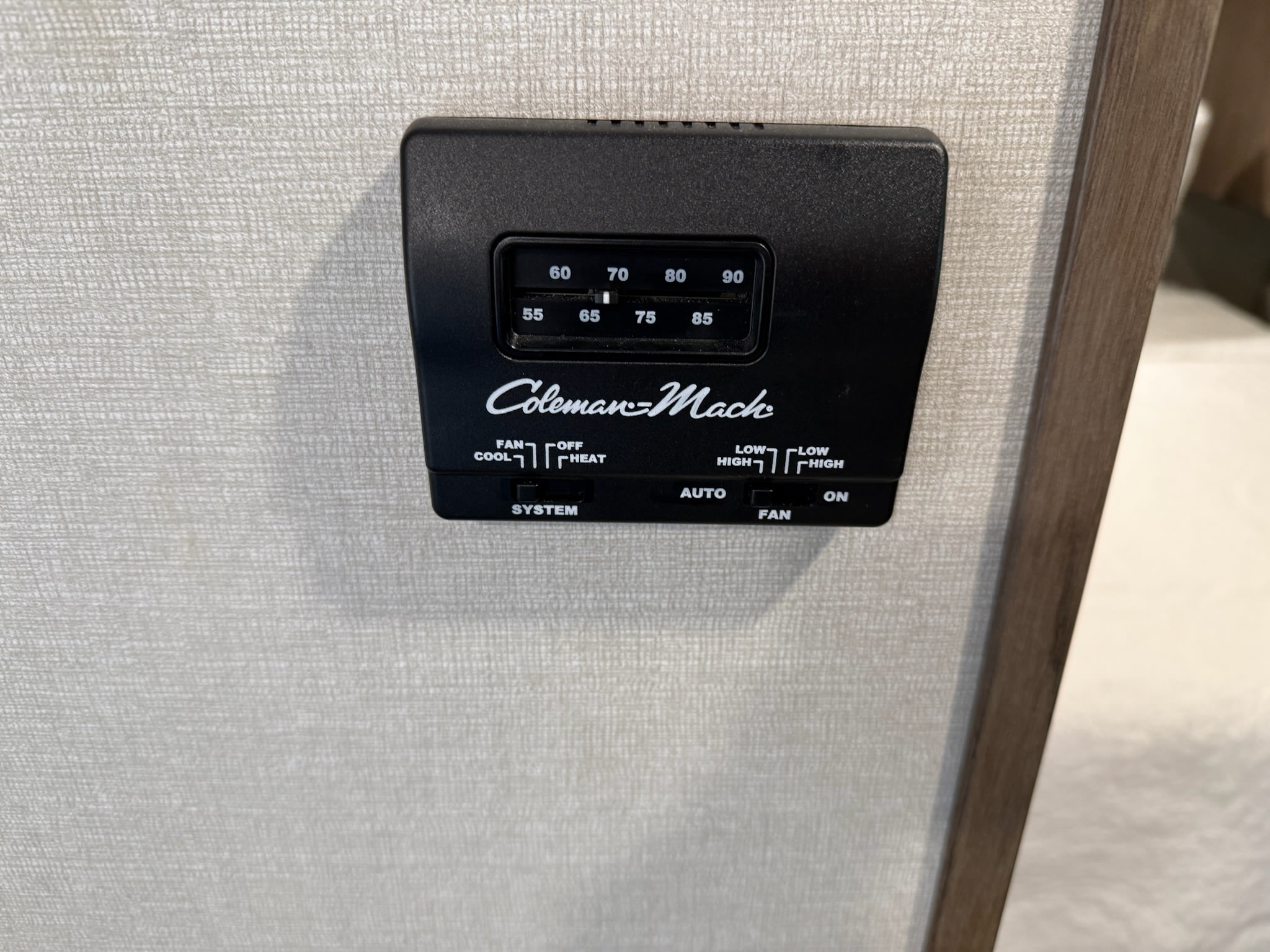 Essential for an **rv rental**: A Coleman-Mach thermostat for climate control, displaying temperature and fan settings.. Forest River Primetime Avenger 27dbs 2021