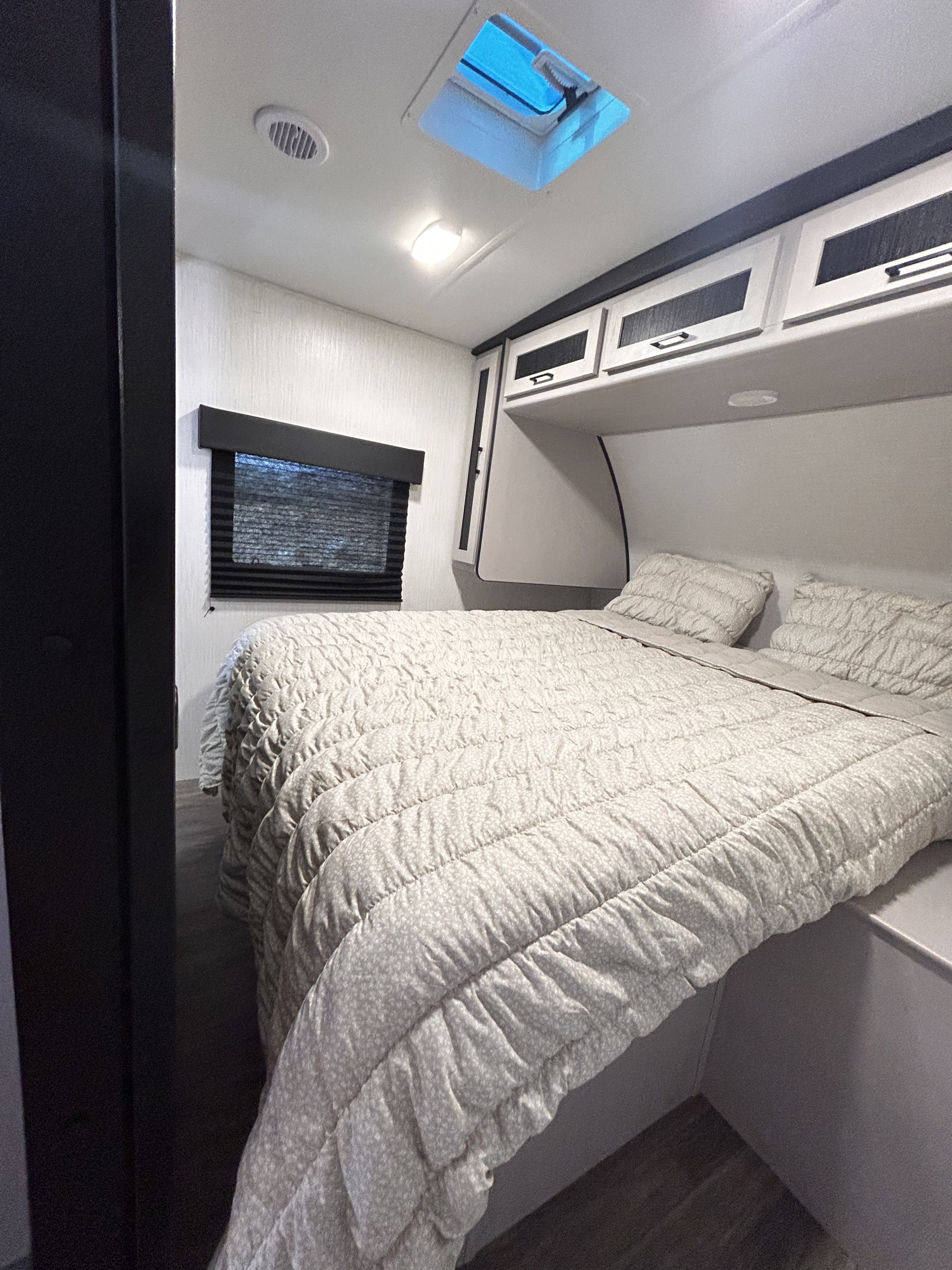 Cozy RV rental bedroom with comfortable bed, overhead storage, and skylight. Perfect for your next adventure.. Heartland RVs Mallard 2024