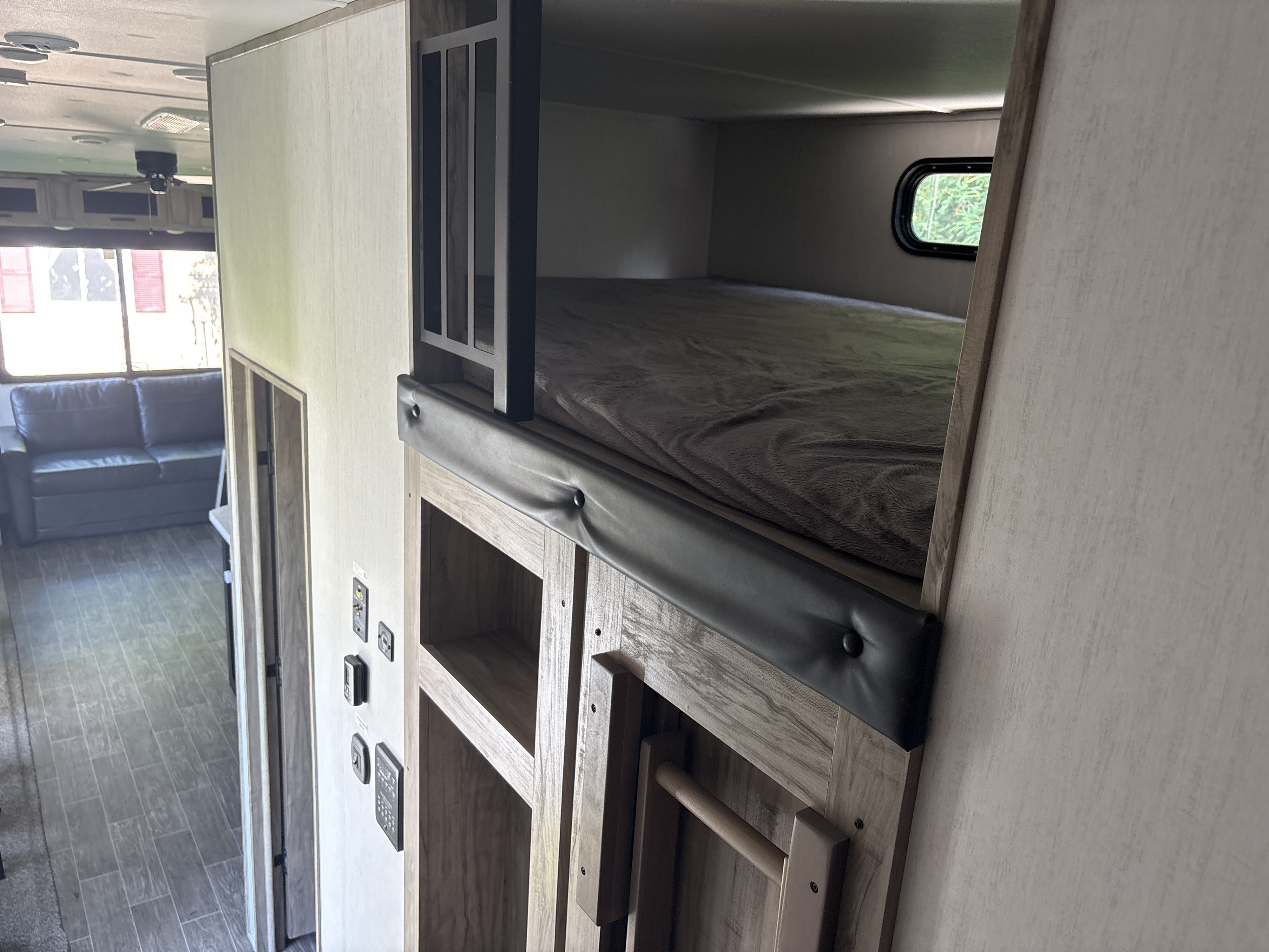 Cozy RV rental interior featuring bunk beds, a sofa, and spacious living area. Perfect for families!. Forest River Cherokee Arctic Wolf 2022
