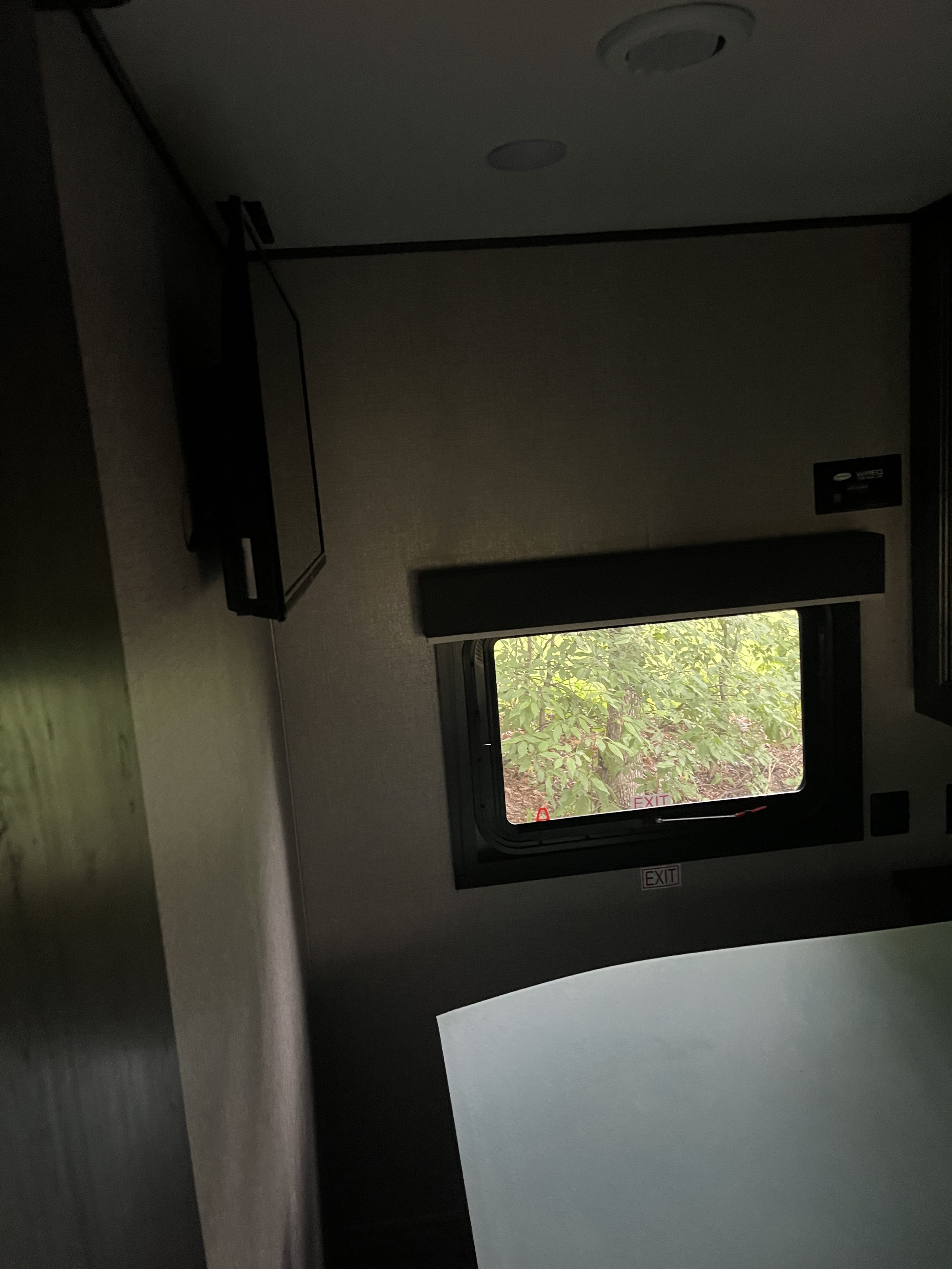 Inside this RV rental: window with nature view, 'EXIT' signs, and a wall-mounted TV.. Jayco Jay Flight SLX 2021