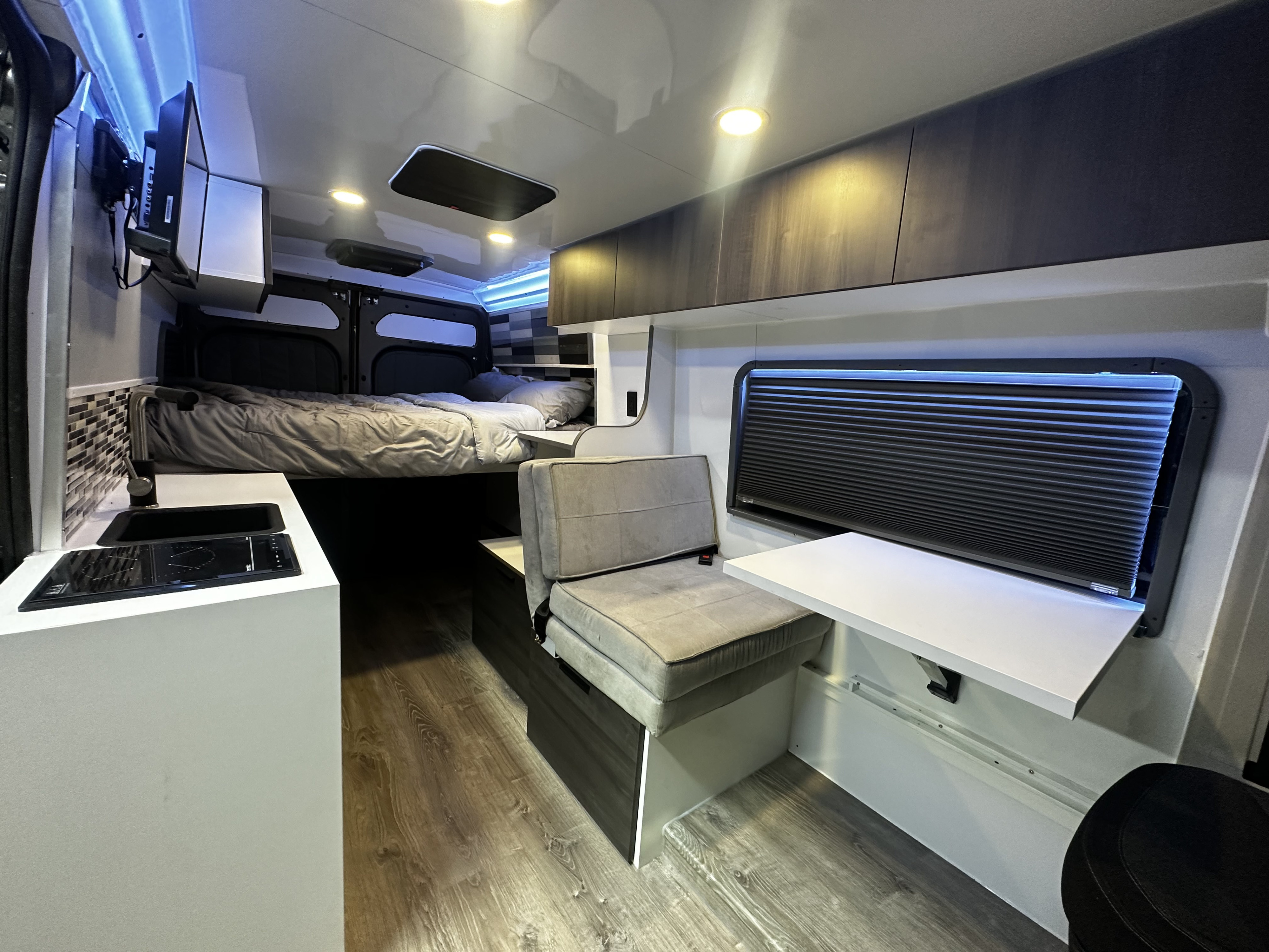 Modern RV rental interior with bed, kitchen, seating, and entertainment for comfort on the road.. Dodge Promaster 2500 2022