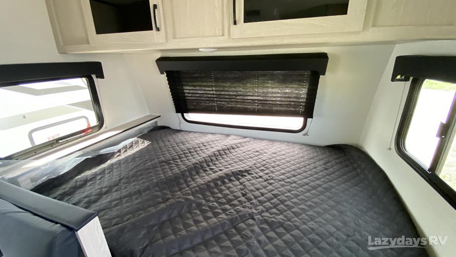 Enjoy comfortable rest in this RV rental's cozy bedroom, with a large bed, windows, and storage.. Coachmen Apex Nano 2023