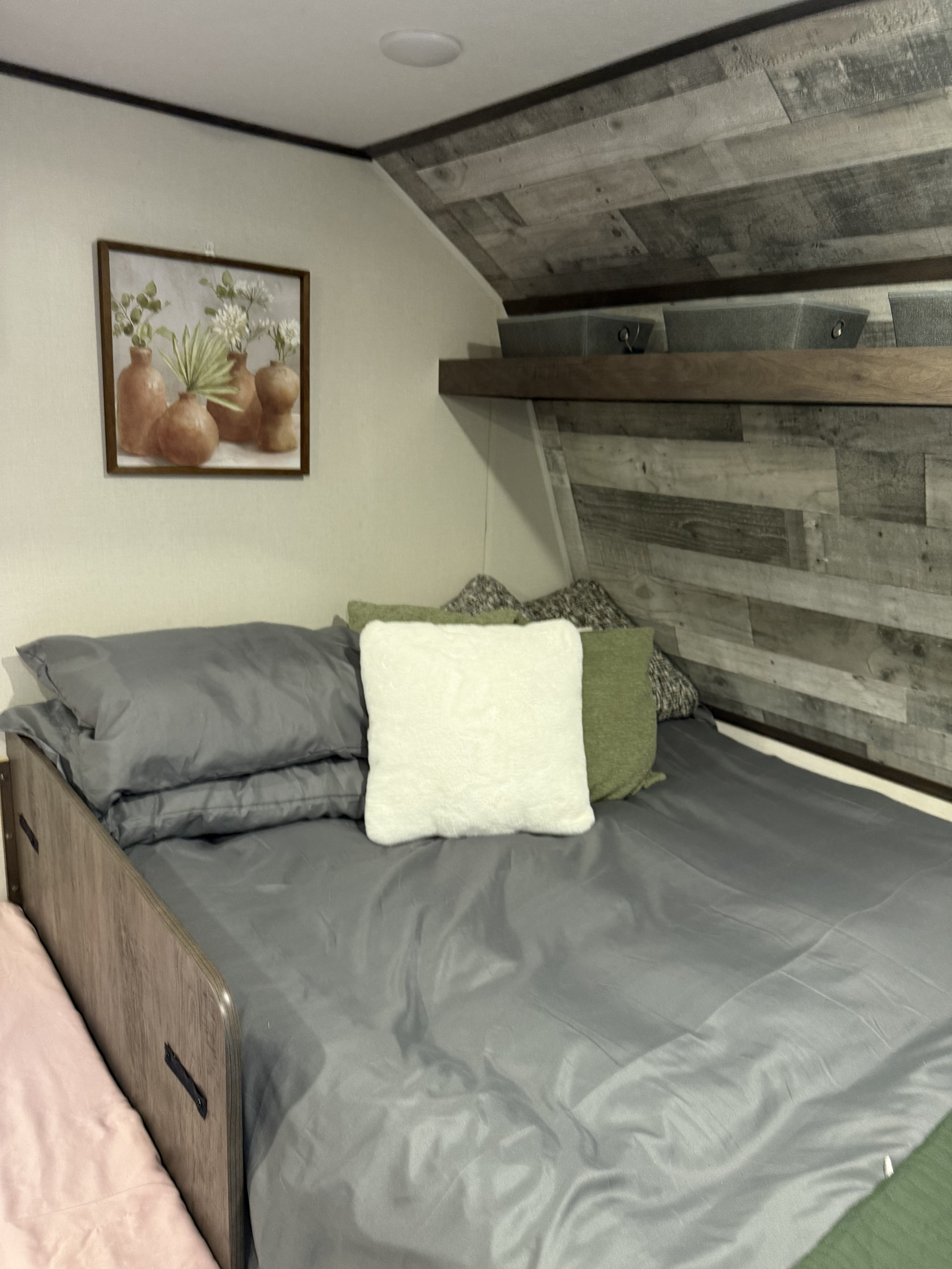 Relax in this well-appointed RV rental bunk area with soft bedding, decorative shelf & art.. Keystone RV Coleman Lantern 17B 2022
