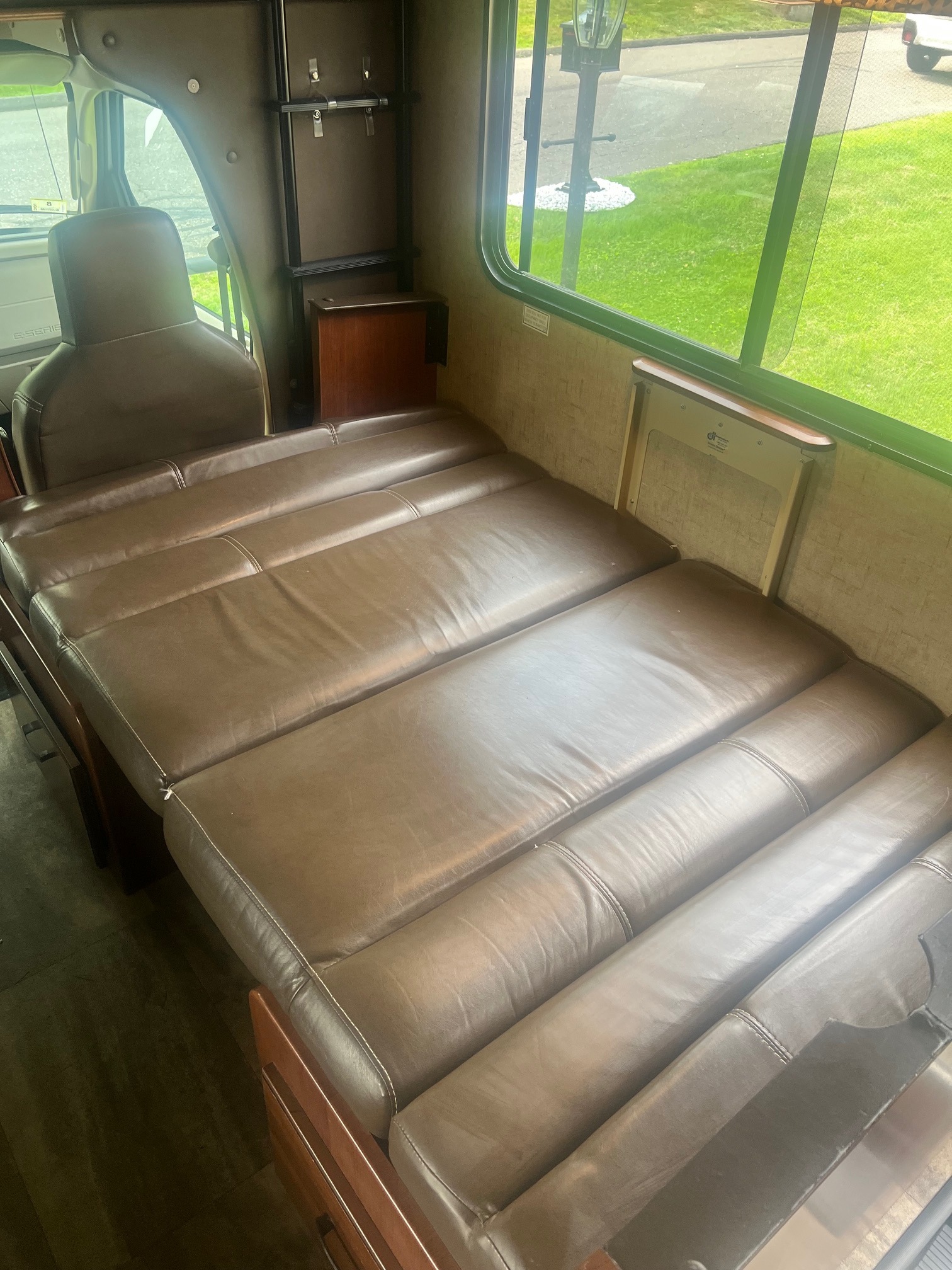 Spacious RV rental interior featuring long convertible seating/bed and large window view. Ideal for travel comfort.. Forest River Sunseeker 2016