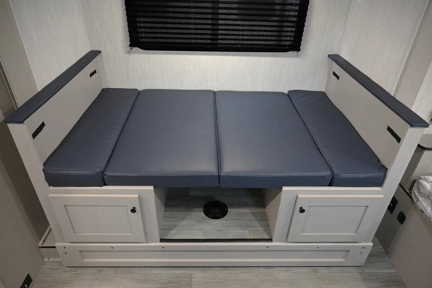 This RV rental's light-wood dinette with blue-gray cushions easily converts to a bed. Includes under-seat storage.. Coachmen Apex Nano 2021