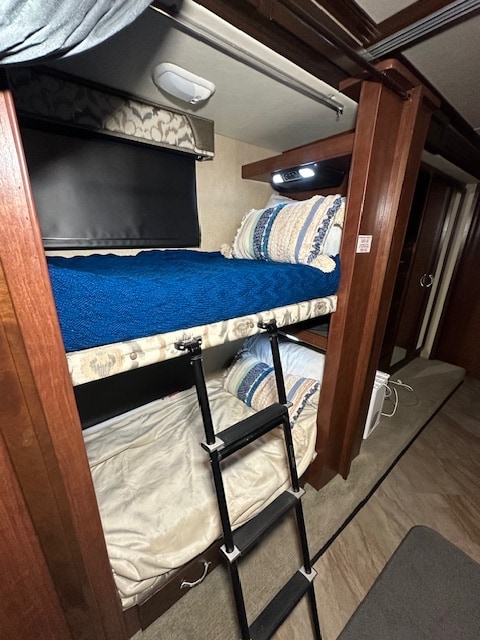 Inside an RV rental: a comfortable sleeping area with bunk beds and a ladder for easy access to the top bunk.. Fleetwood Bounder 2017