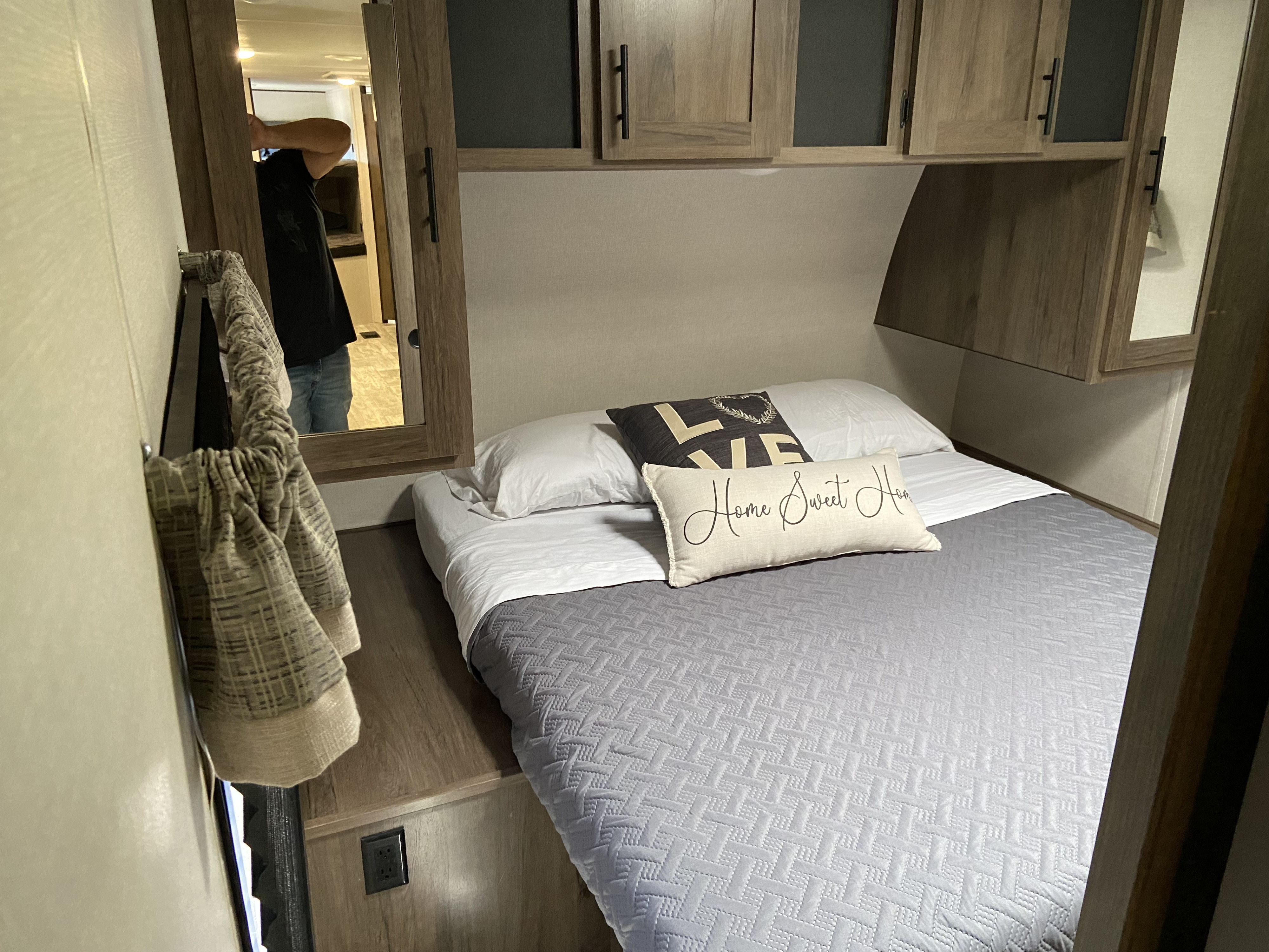 Inside a cozy RV rental: a compact bedroom with a bed, overhead cabinets, and decor. Perfect for travel adventures.. Avenger SZT2AVTB1MB928831 2021