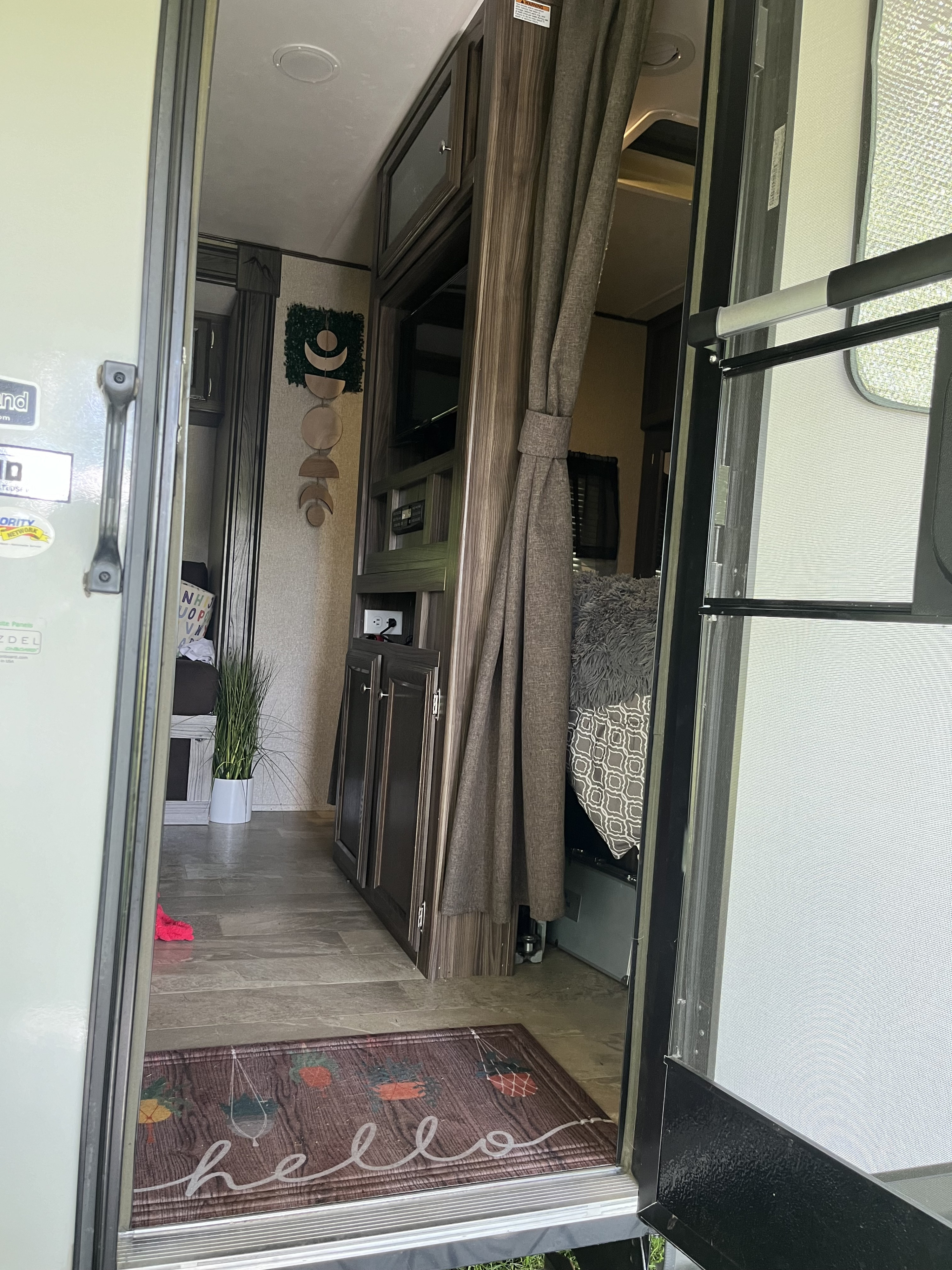 Step inside this cozy RV rental's living space, featuring a welcoming mat, decorative wall art, and practical amenities.. Coachmen Apex Ultra-Lite 28LE 2019