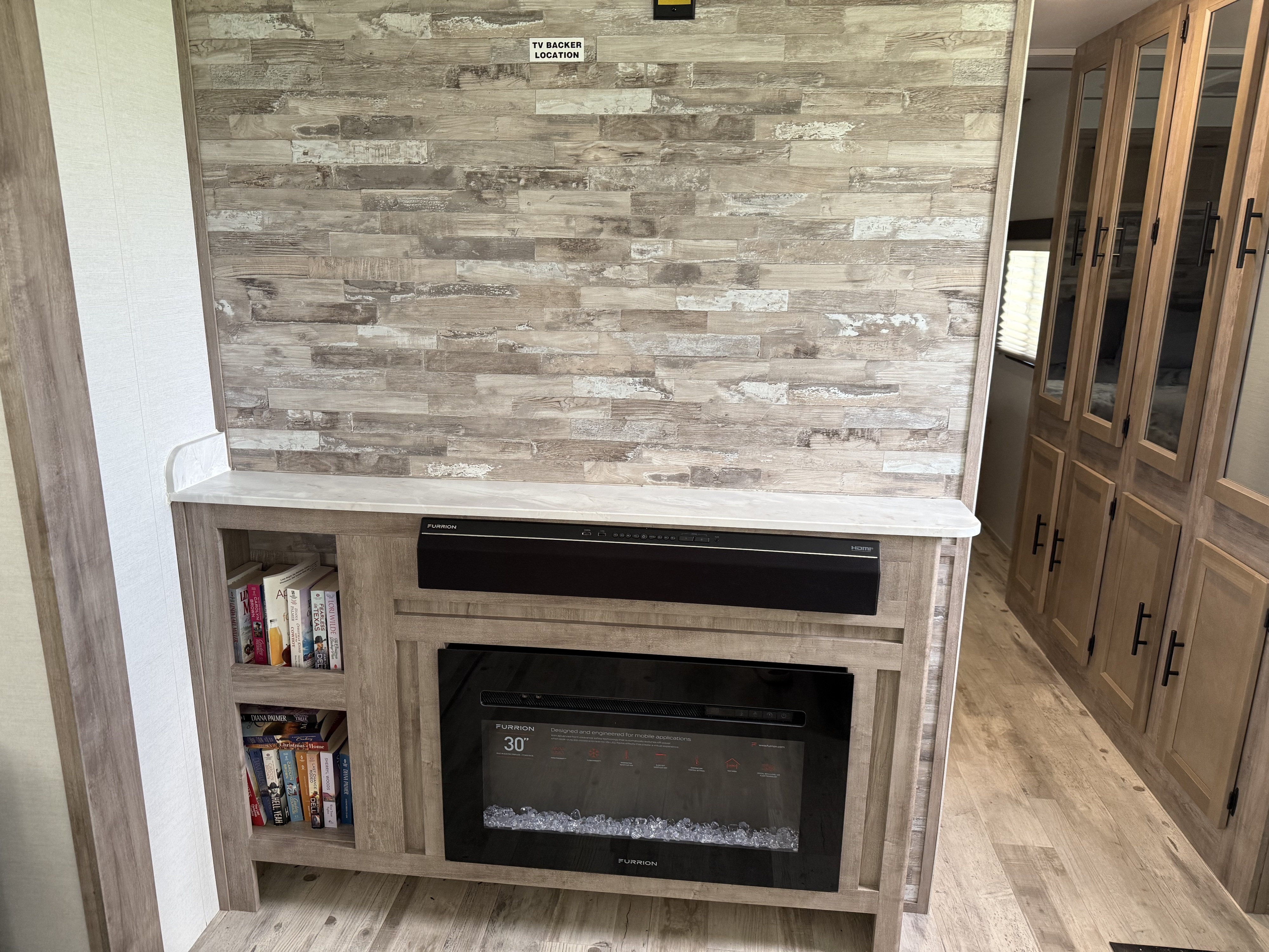 Experience comfort in this RV rental: an interior entertainment setup with electric fireplace, soundbar, & storage.. Gulf Stream Kingsport Supreme 2024