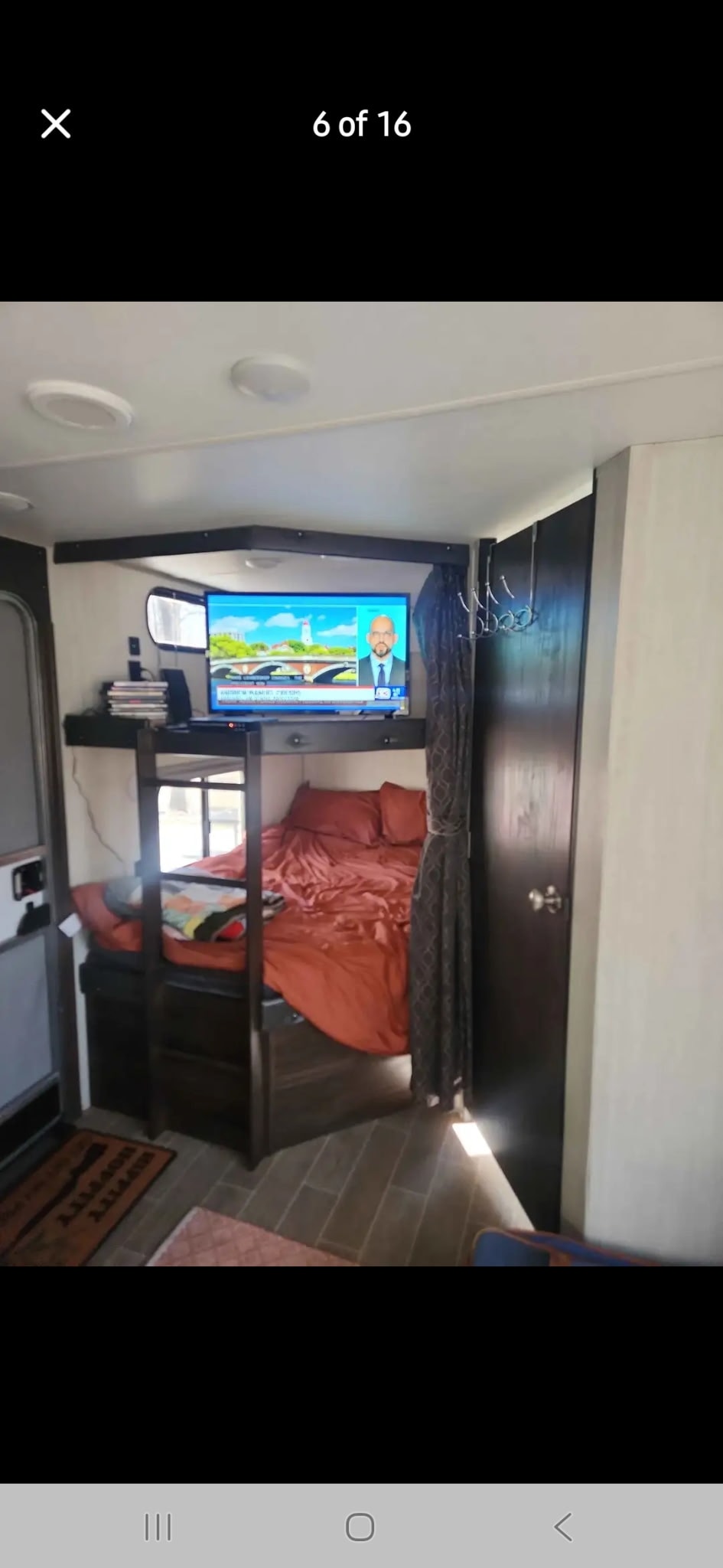 Cozy RV rental interior featuring bunk beds with red bedding, a TV, and a functional small space.. Forest River Cherokee 2020